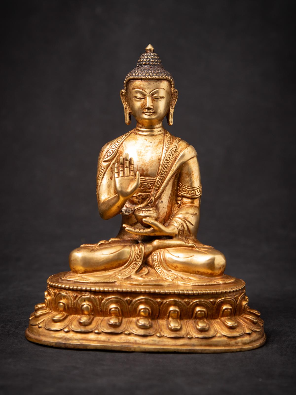 Discover this old bronze Nepali Buddha statue, an exquisite piece of spiritual art from the middle 20th century. Crafted from high-quality bronze and fire gilded with 24 karat gold, it showcases the Abhaya mudra, symbolizing fearlessness and