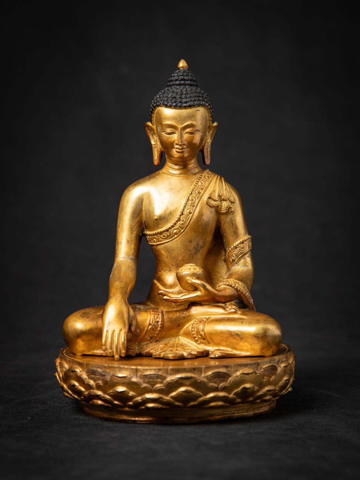 Cette statue de Bouddha népalais en bronze ancien est une œuvre d'art bouddhiste du Népal datant du milieu du 20e siècle, d'une grande beauté. Réalisée en bronze et dorée à l'or fin 24 carats, elle mesure 20,5 cm de haut, 14,2 cm de large et 14,2 cm