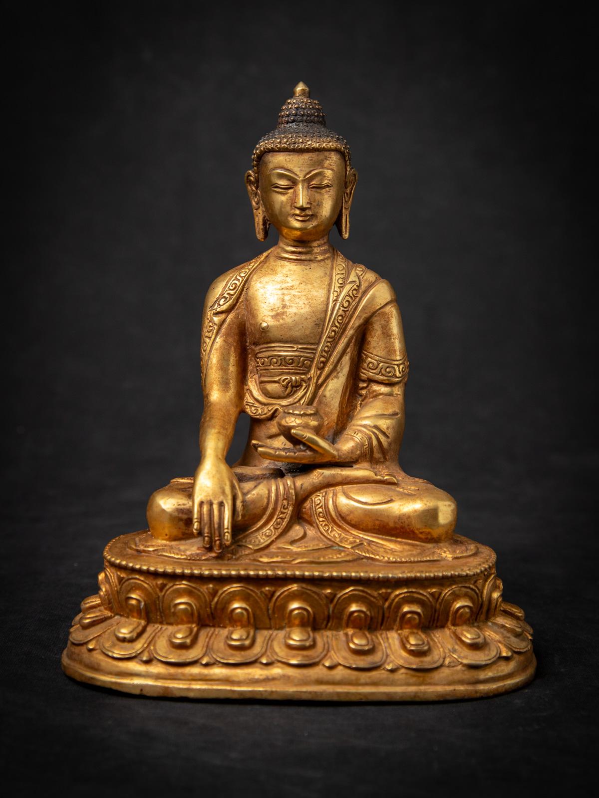 Diese alte nepalesische Buddha-Statue aus Bronze aus der Mitte des 20. Jahrhunderts ist ein fein gearbeitetes Beispiel für die buddhistische Kunst des Himalaya. Die aus Bronze gefertigte und mit 24 krt. Gold feuervergoldete Statue ist 21,2 cm hoch,
