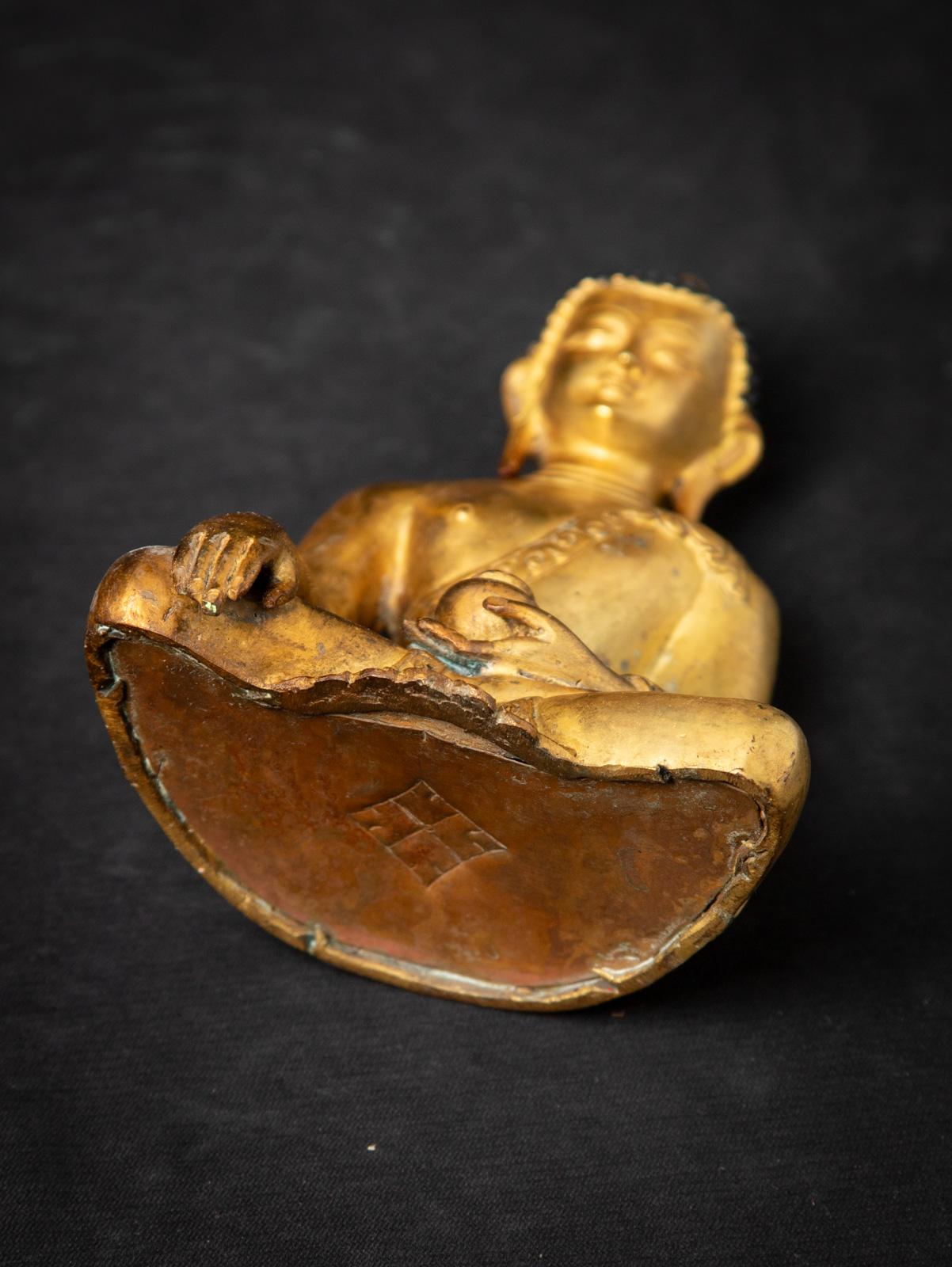 Diese alte nepalesische Buddha-Statue aus Bronze aus der Mitte des 20. Jahrhunderts ist ein fein gearbeitetes Devotionalienstück, das das reiche buddhistische Erbe Nepals widerspiegelt. Die aus Bronze gefertigte und mit 24-karätigem Gold