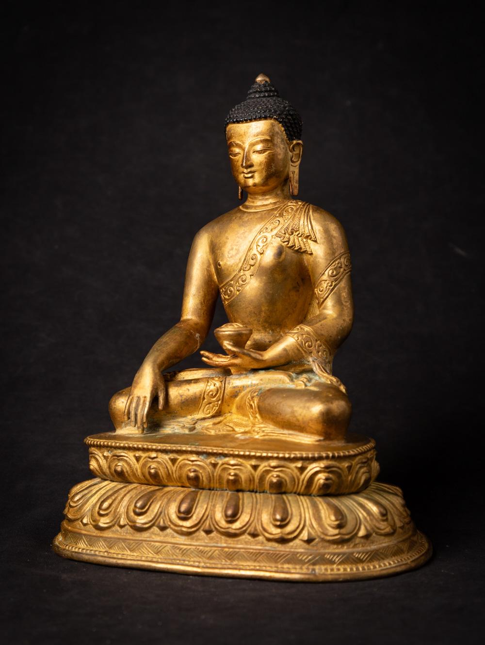 The old bronze Nepali Buddha statue is a striking testament to the artistic and spiritual heritage of Nepal. Crafted from bronze, this statue stands at a height of 23.9 cm, with dimensions of 19.8 cm in width and 14.4 cm in depth. Its intricate