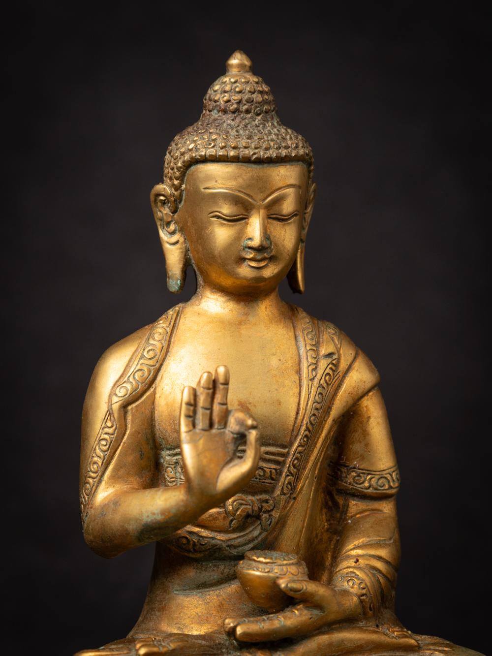 The old bronze Nepali Buddha statue is a captivating and spiritually meaningful artifact originating from Nepal. Crafted from bronze and adorned with fire gilding in 24-karat gold, this statue stands at 21.5 cm in height and measures 17.5 cm in