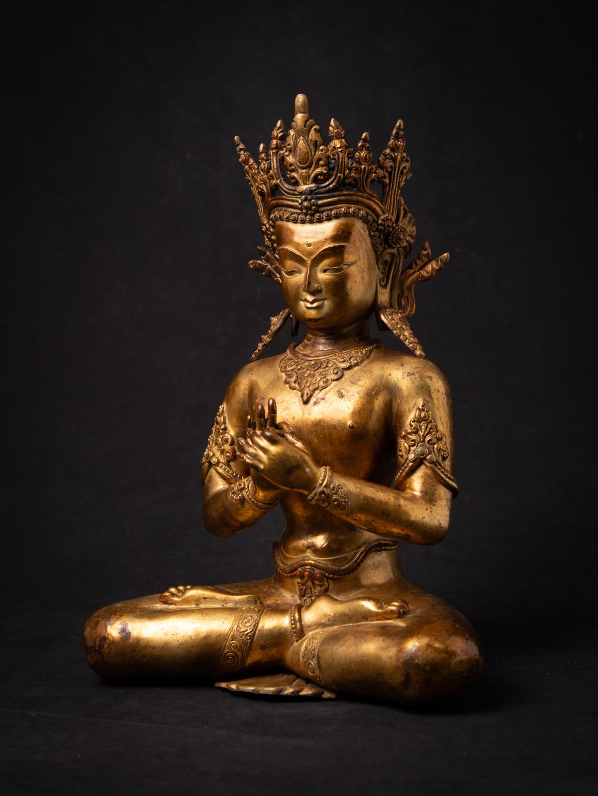 Scopri la bellezza dell'artigianato tradizionale nepalese con questa statua di Buddha in bronzo, un pezzo di alta qualità risalente alla metà del XX secolo. Sapientemente dorata a fuoco con oro a 24 carati, questa squisita statua è alta 37 cm, larga