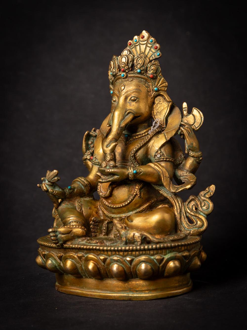 This old bronze Nepali Ganesha statue is a remarkable representation of the Hindu deity Ganesha, known as the remover of obstacles and the god of new beginnings. Crafted from bronze and standing at 20.7 cm in height, with dimensions of 16.3 cm in