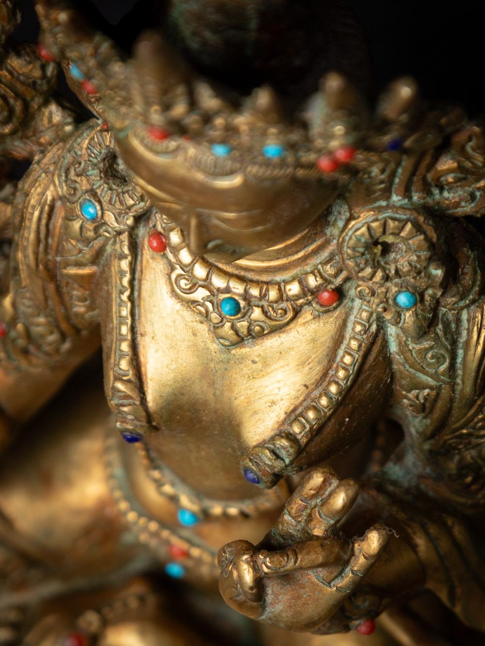 This old bronze Nepali Green Tara statue is a magnificent representation of a revered deity in Himalayan Buddhism. Crafted from bronze, it stands at a height of 22.2 cm, with a width of 17.3 cm and a depth of 13.2 cm, making it a substantial and