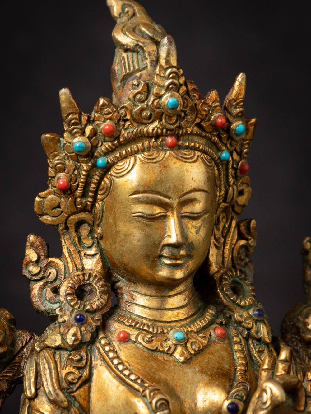 This old bronze Nepali Green Tara statue is a magnificent representation of a revered deity in Himalayan Buddhism. Crafted from bronze, it stands at a height of 22.1 cm, with a width of 17.5 cm and a depth of 13.1 cm, making it a substantial and