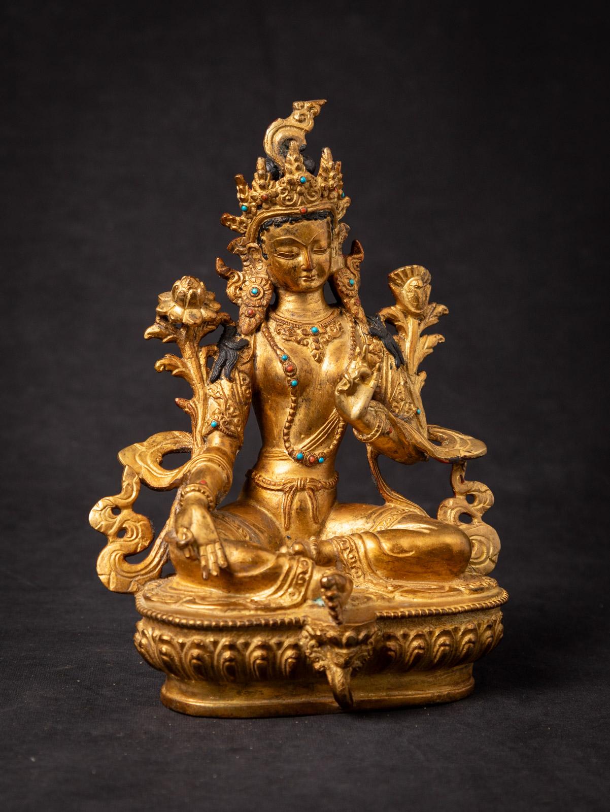This old bronze Nepali Green Tara statue is a magnificent representation of a revered deity in Himalayan Buddhism. Crafted from bronze, it stands at a height of 21,3 cm, with a width of 15,7 cm and a depth of 10,5 cm, making it a substantial and