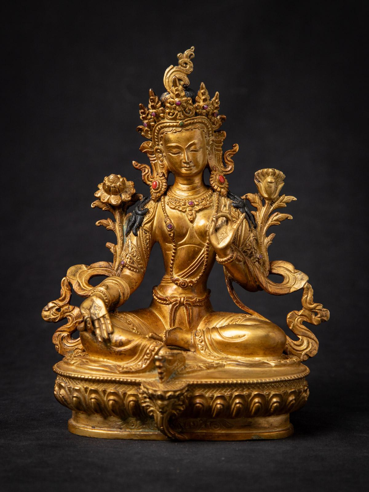 Cette statue de Tara verte népalaise en bronze ancien est un artefact captivant et spirituellement riche, fabriqué au milieu du XXe siècle au Népal. Réalisée en bronze massif, la statue mesure 22,4 cm de haut, 17,5 cm de large et 11,4 cm de