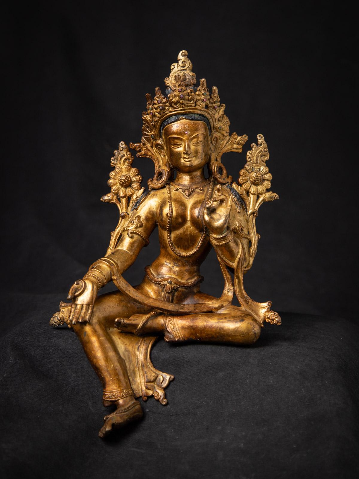 Cette statue de Tara verte népalaise en bronze ancien est un exemple stupéfiant de l'artisanat himalayen du milieu du XXe siècle, rayonnant à la fois de symbolisme spirituel et d'excellence artistique. Mesurant 26 cm de hauteur, 16,5 cm de largeur