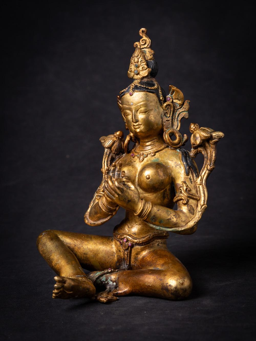This old bronze Nepali Green Tara statue is a magnificent representation of the revered deity. Crafted from bronze and standing at a height of 20.4 cm, with dimensions of 14 cm in width and 11.9 cm in depth, this statue exudes elegance and spiritual