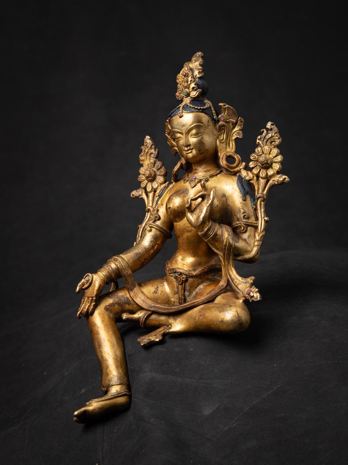 This old bronze Nepali Green Tara statue is an exquisite representation of a revered figure in Tibetan Buddhism. Crafted from bronze, it stands at a height of 26 cm, with dimensions of 15,9 cm in width and 11,6 cm in depth, making it a beautifully