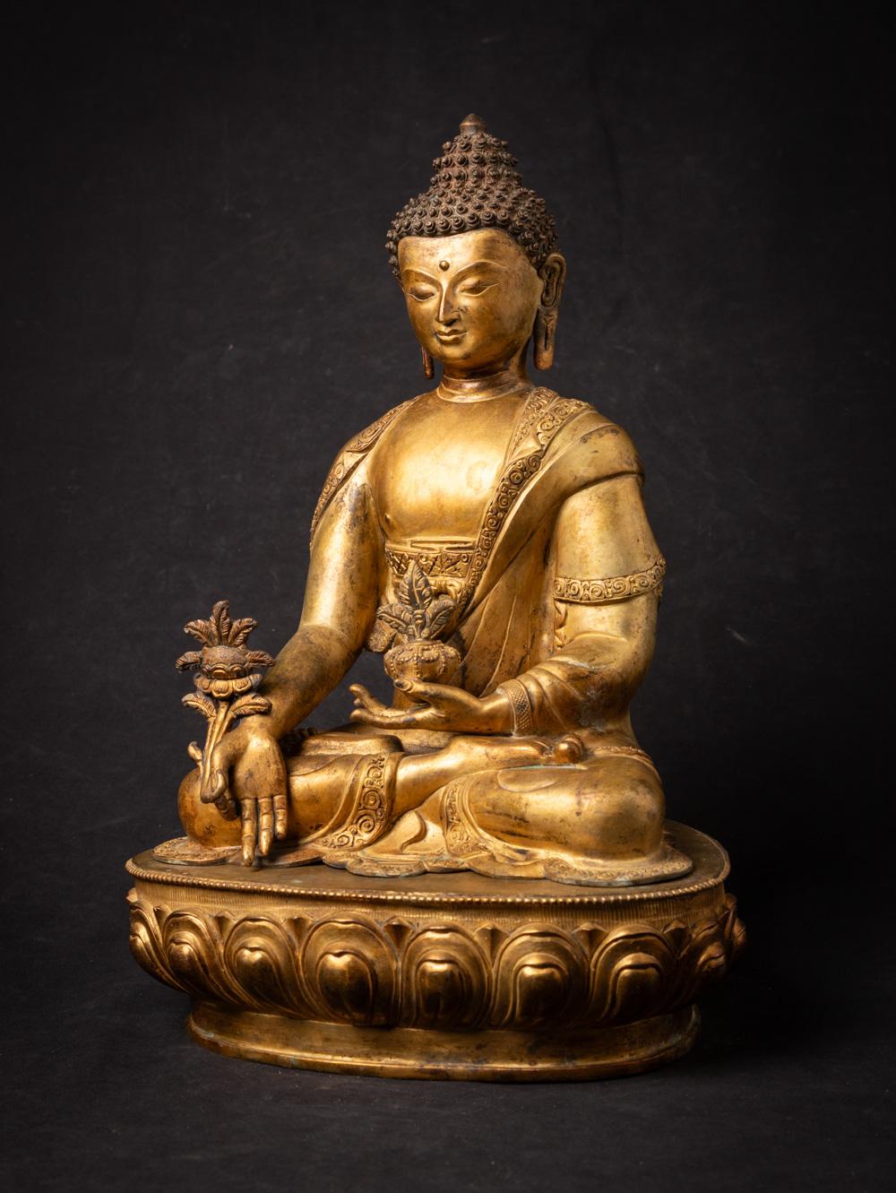 This old bronze Nepali Medicine Buddha statue is a true masterpiece of craftsmanship and spirituality. Standing at a majestic 44.5 cm in height, with dimensions of 30.5 cm in width and 23 cm in depth, it is a substantial representation of the