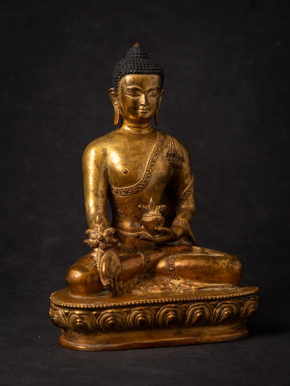This old bronze Nepali Medicine Buddha statue is a true masterpiece of craftsmanship and spirituality. Standing at a majestic 21.7 cm in height, with dimensions of 15.5 cm in width and 10.2 cm in depth, it is a substantial representation of the