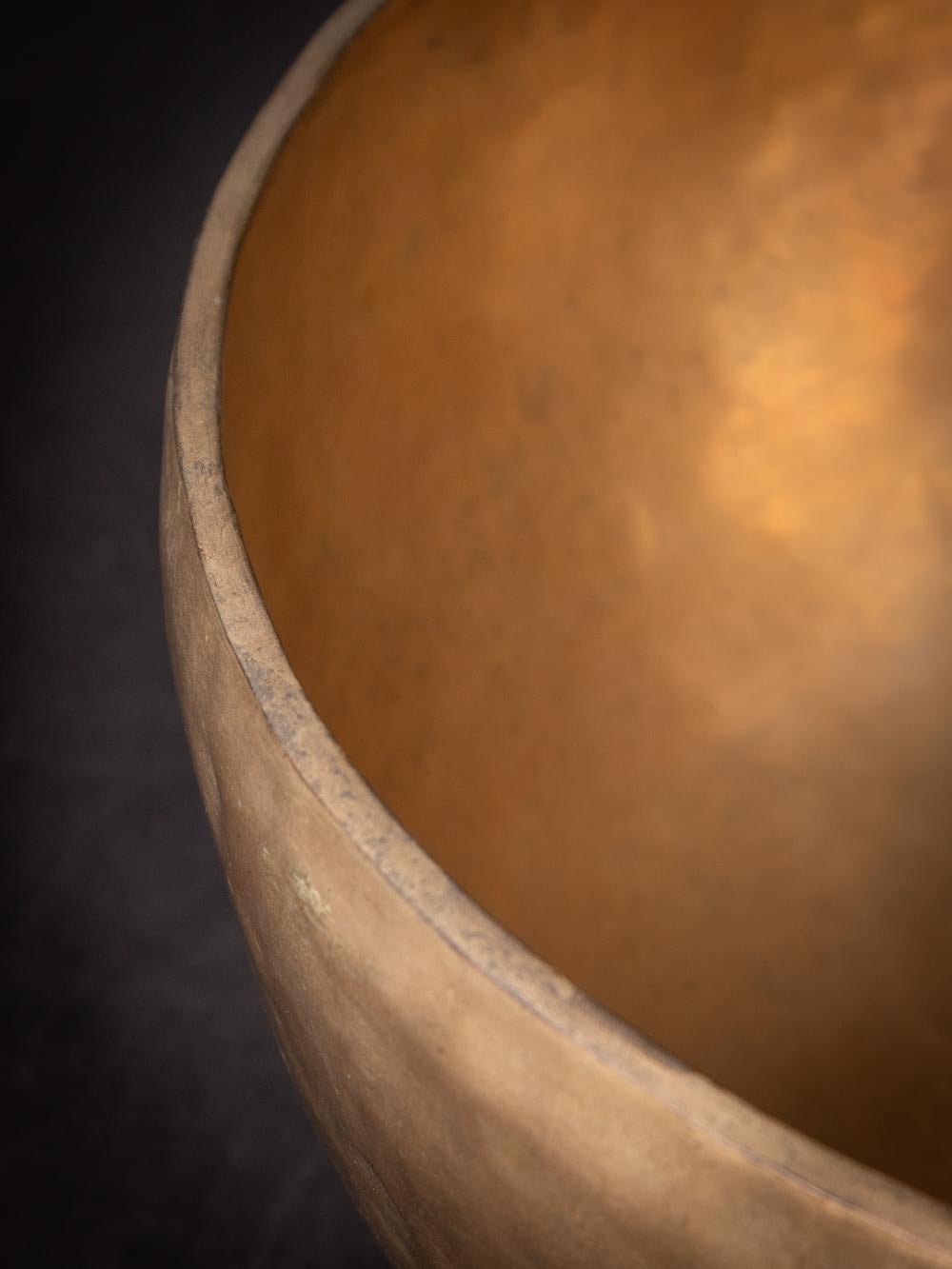 The Old bronze Nepali Singing bowl from Nepal is a testament to the skilled craftsmanship and musical tradition of the region. Created from bronze, this singing bowl stands at a height of 16,3 cm and has a diameter of 38,2 cm. Crafted with a focus