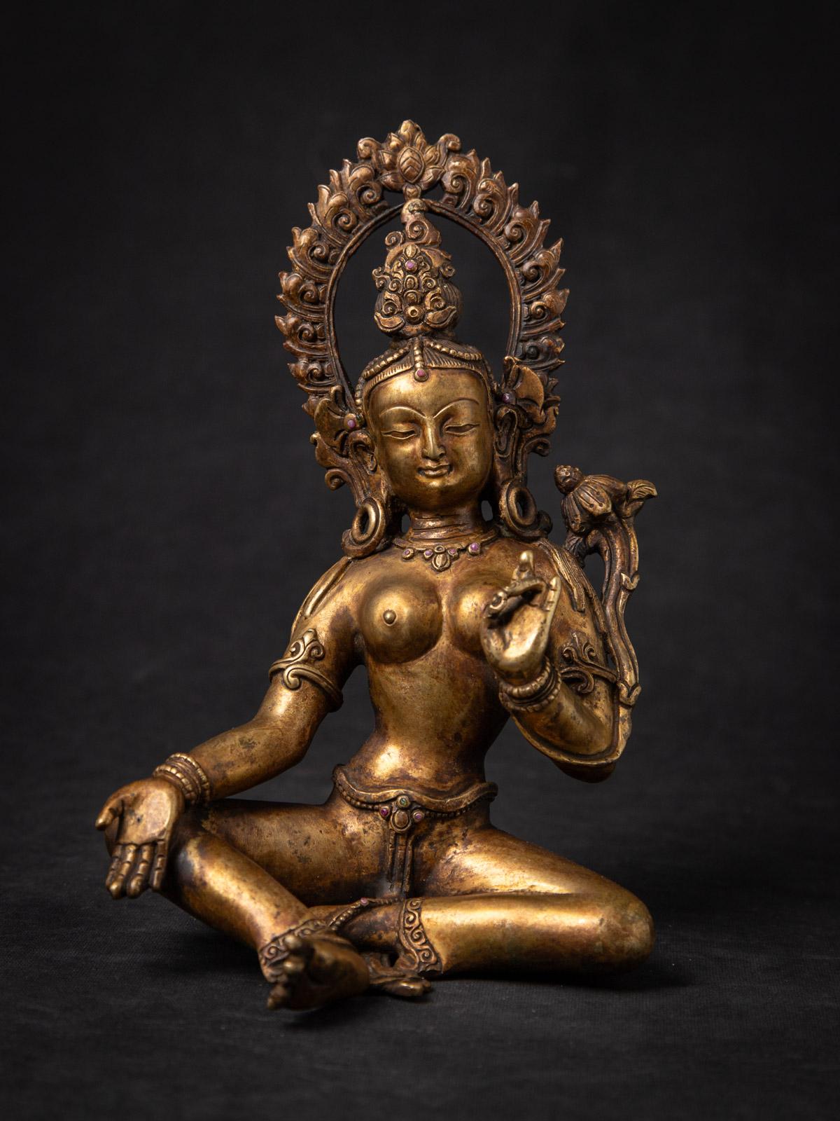 Questa antica statua di Tara nepalese in bronzo è un manufatto grazioso e spiritualmente significativo della metà del XX secolo, magistralmente realizzato a mano in Nepal, una regione rinomata per le sue sculture sacre in bronzo. Con un'altezza di