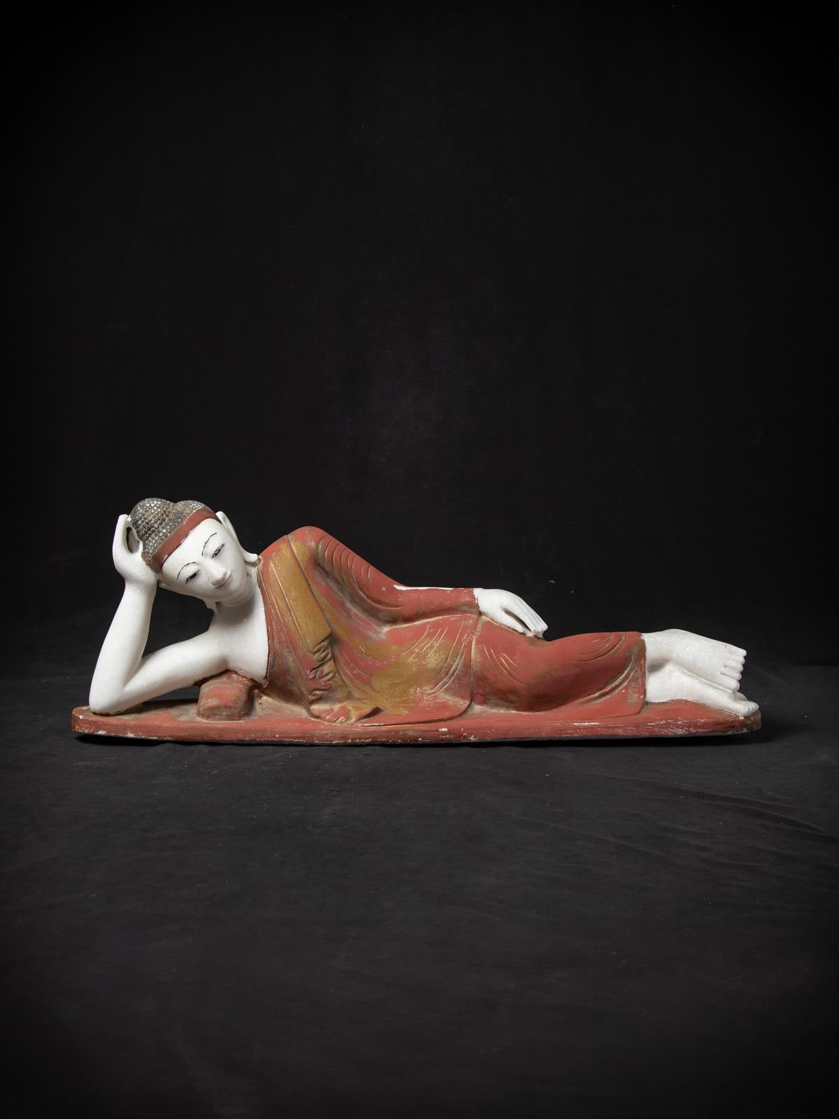 This old marble reclining Buddha statue from the mid-20th century is a remarkable example of Mandalay style Buddhist art from Burma (Myanmar). Carved from marble, the statue measures 33 cm high, 93 cm wide, and 19 cm deep, with a substantial weight
