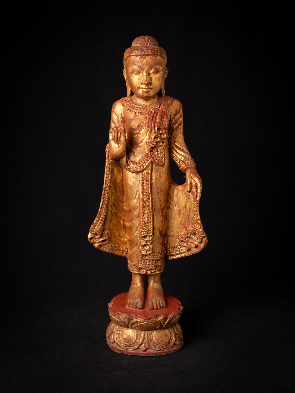 Cette ancienne statue de Bouddha birmane en bois est une pièce finement travaillée datant du milieu du XXe siècle, reflétant le style traditionnel de Mandalay de l'art birman. Réalisée en bois et dorée à l'or fin 24 krt., elle mesure 55 cm de haut,