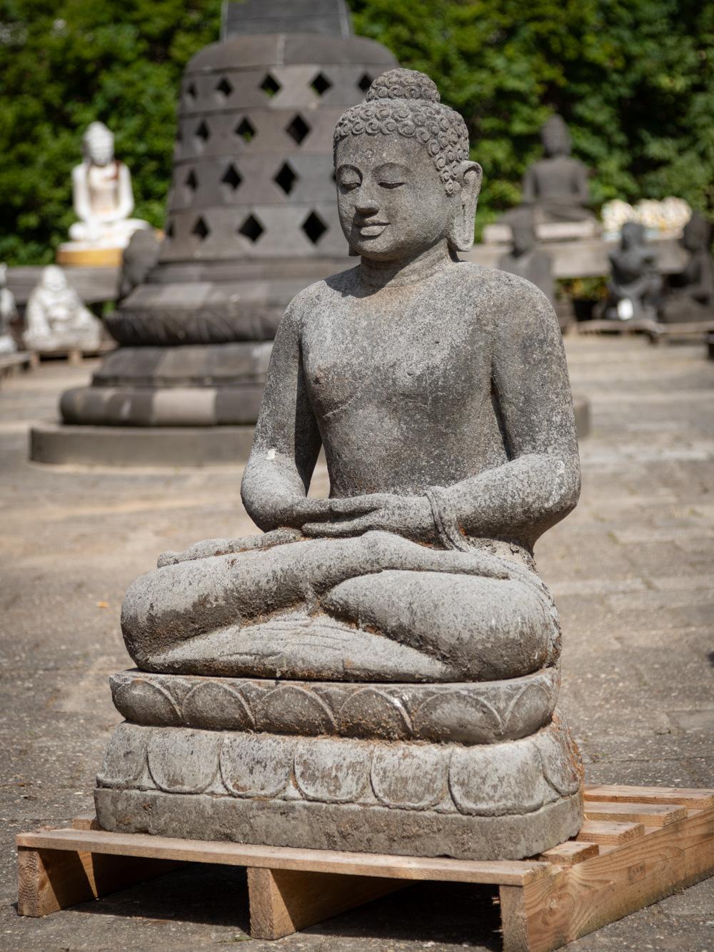 This old lavastone Buddha statue from Indonesia is a captivating work of art and spirituality. Crafted from lavastone, it stands at an impressive height of 104 cm, with dimensions of 68 cm in width and 48 cm in depth. Estimated to weigh