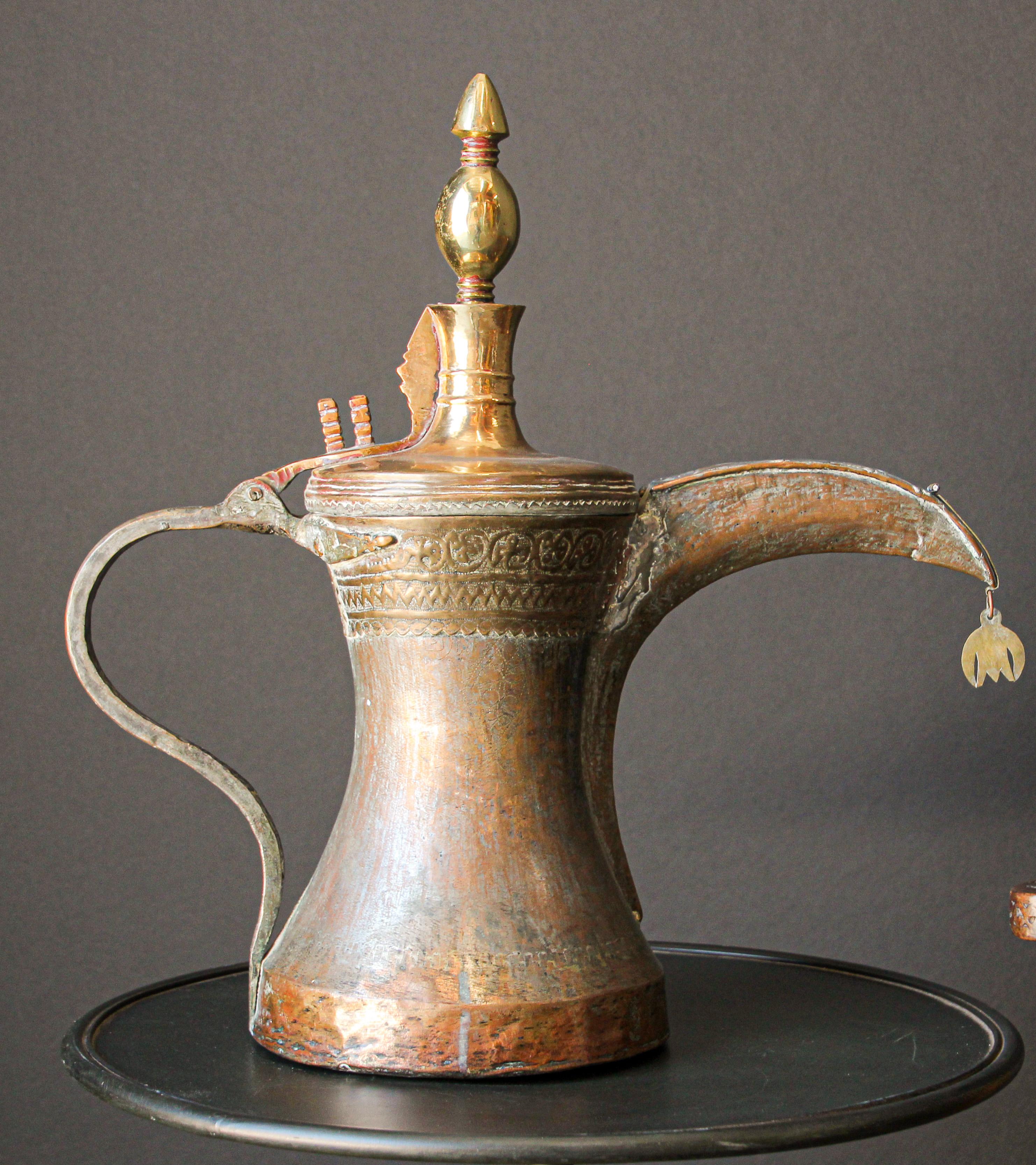 19th century Middle Eastern Arabian oversized tinned copper Dallah coffee pot.
Huge oversized antique Arabic Bedouin Dallah brass coffee pot hand-hammered and chased copper with riveted finish.
This Middle Eastern Dallah Arabic Bedouin coffee pot