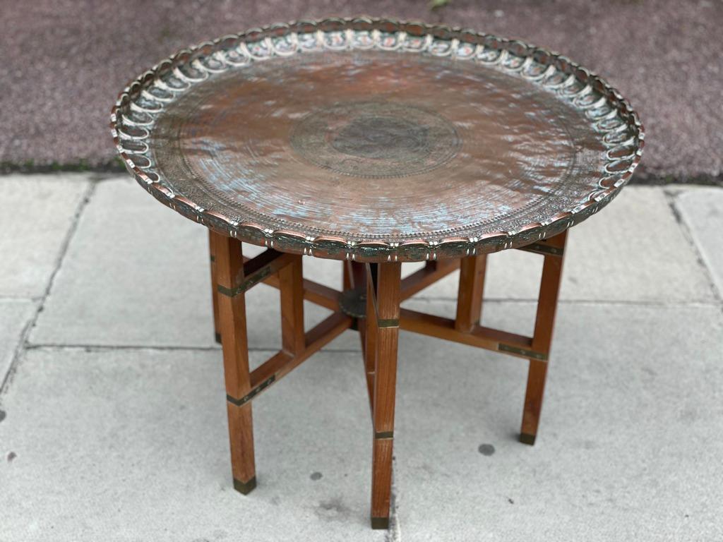 Middle Eastern copper coffee table. Round tray table finely handcrafted, etched, hammered and incised with Moorish designs, faces, leaves and intricate patterns with lovely scalloped edges. Hard to find collector one of a kind metal copper art work.