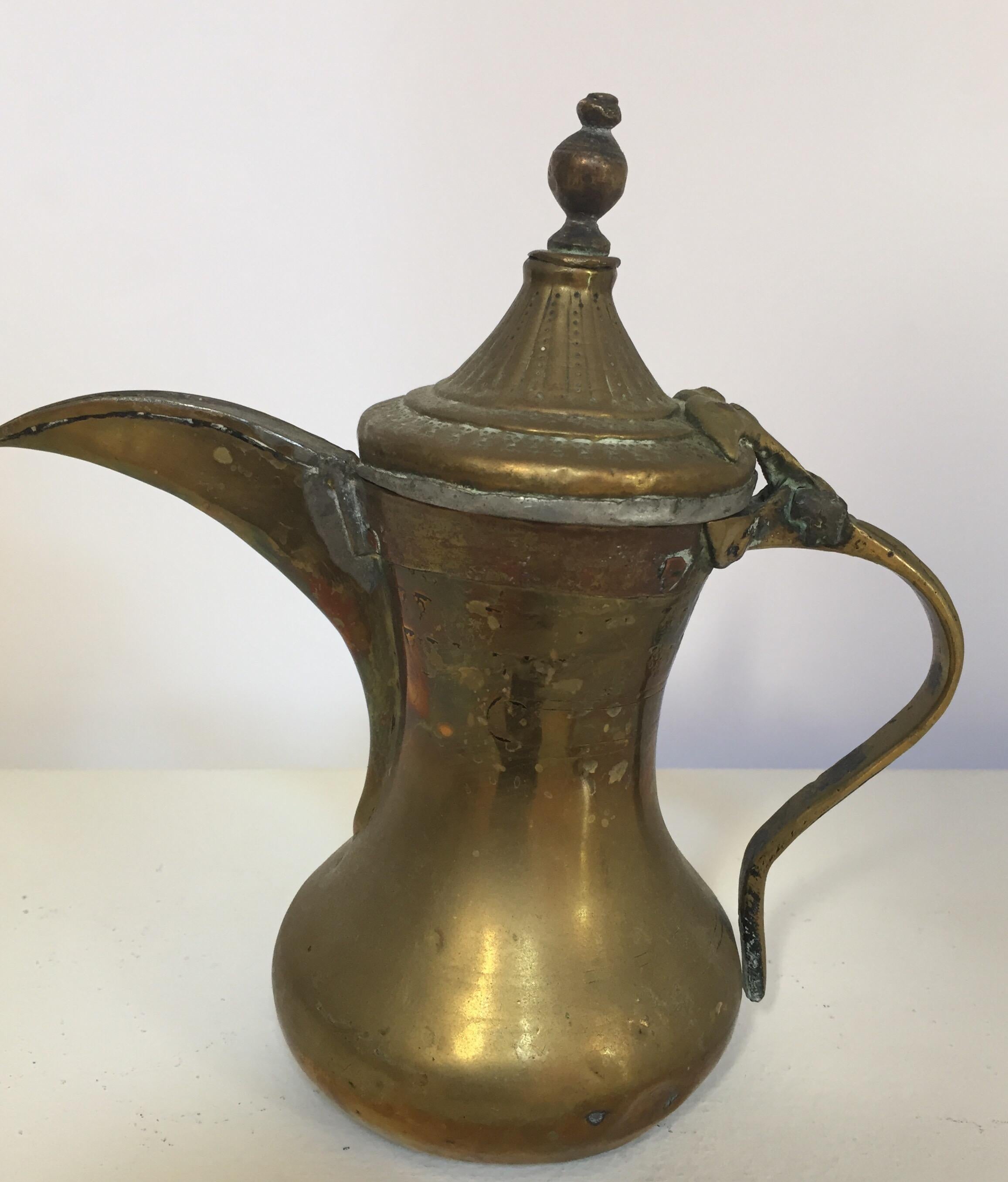 Middle Eastern traditional Arabian tinned copper and brass Dallah coffee pot.
Coffee pot hand-hammered and chased copper with riveted brass finish and a very large spout.
Size: 9