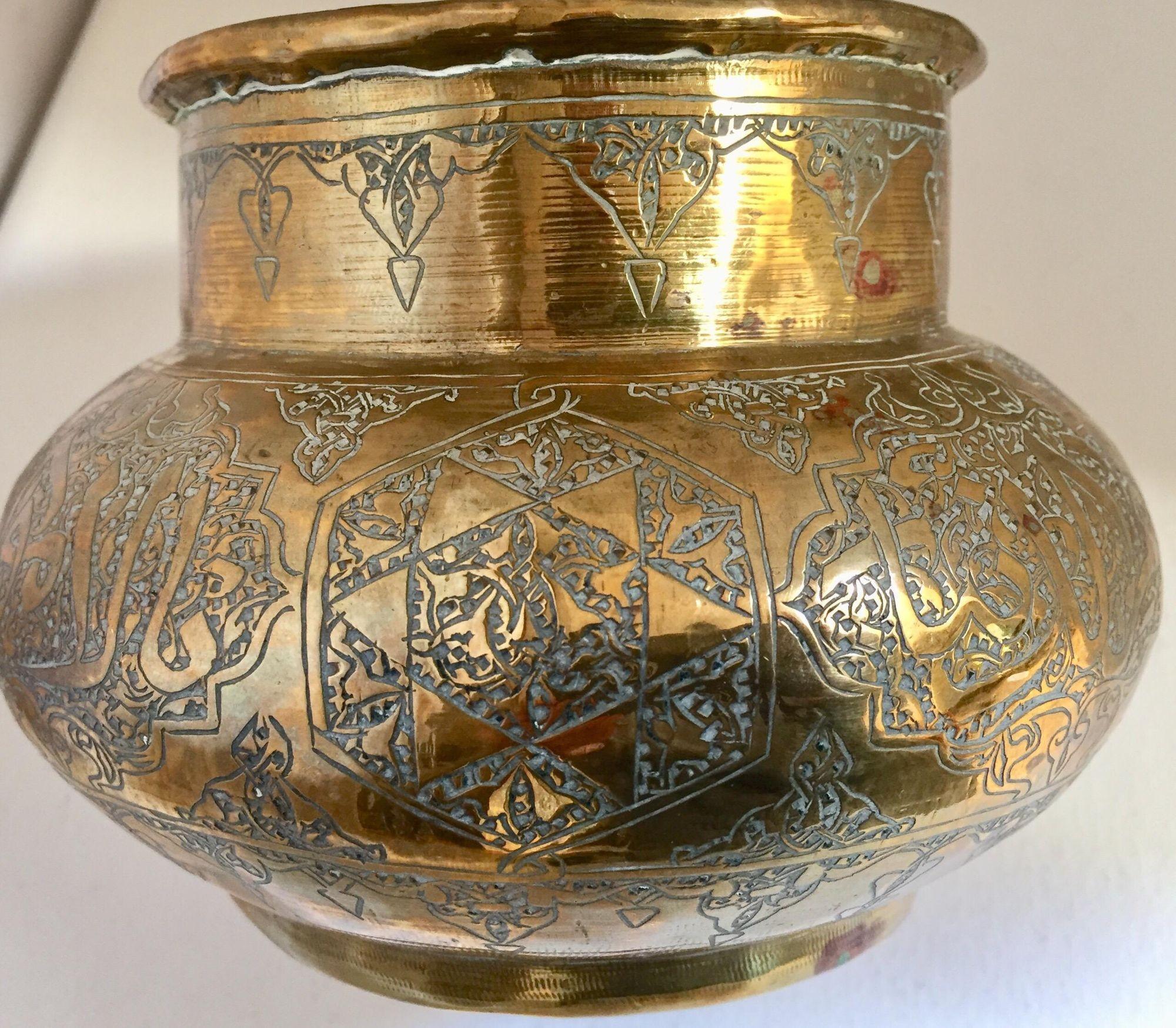 Brass Middle Eastern Egyptian Islamic bowl finely and heavily hand-etched and hand carved with Arabic calligraphy writing inscriptions.
Islamic hand-etched Moorish style brass vessel.
Engraved and hand-chased Arabic Islamic calligraphy and geometric