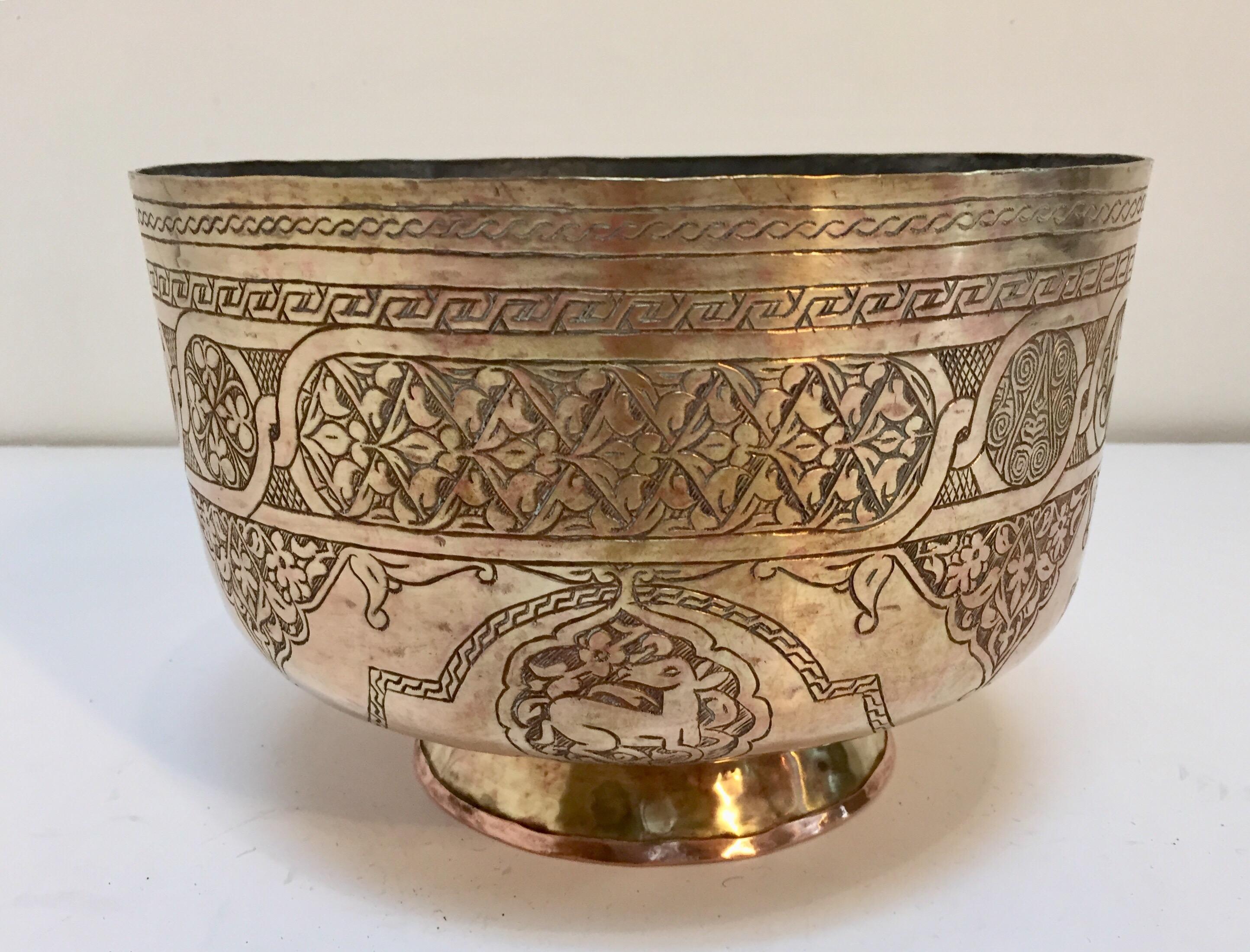 Large Middle Eastern Islamic finely hand-etched brass memorial footed bowl decorated with medallions with Islamic calligraphy inscriptions and scene of wild animals.
Moorish style heavy brass bowl could be used as a jardiniere for a large orchids