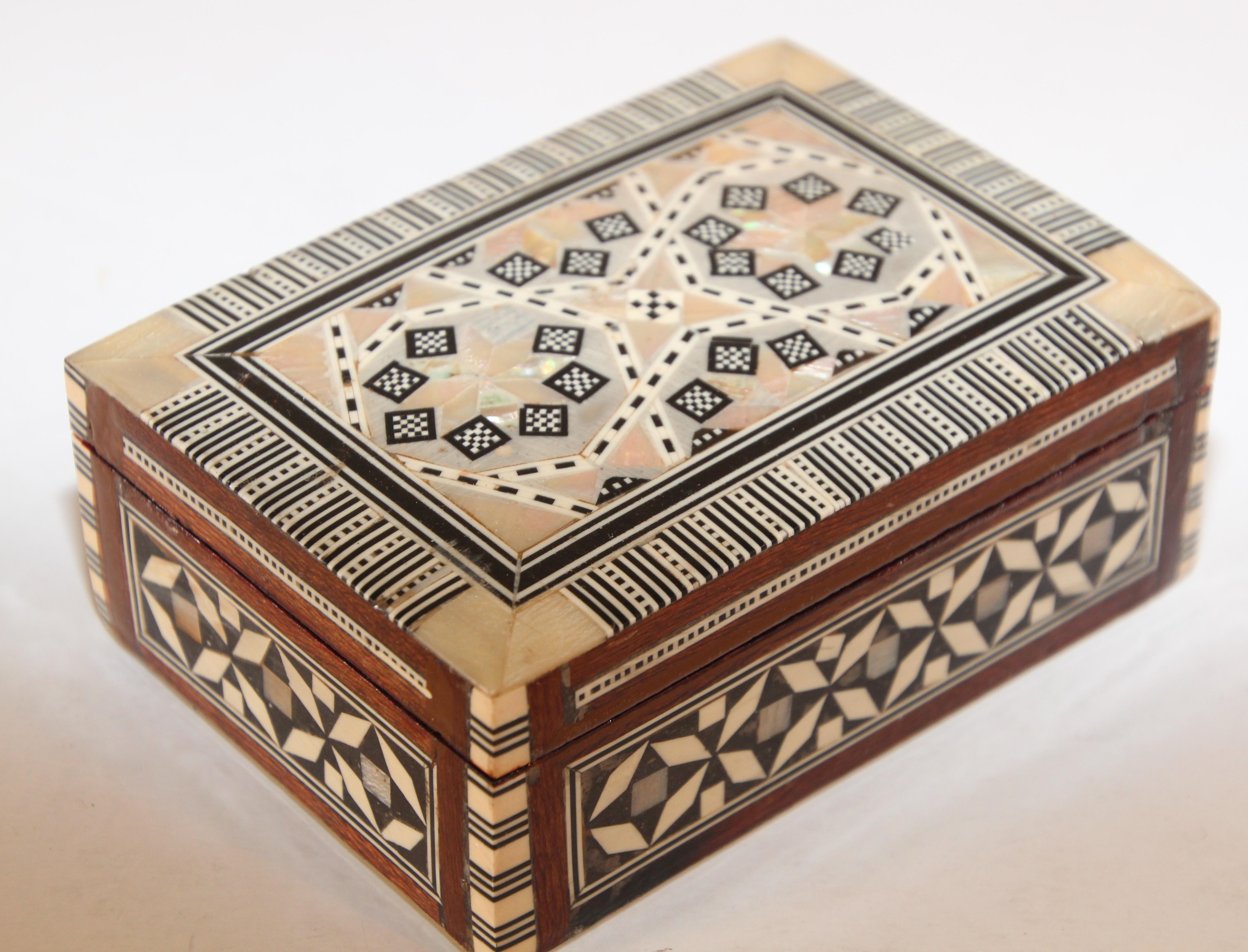 Exquisite handcrafted Middle Eastern mosaic marquetry inlaid walnut wood box.
Small box intricately decorated with Moorish motif designs which have been painstakingly inlaid with mosaic marquetry, mother of pearl and fruitwoods.
Middle Easter,