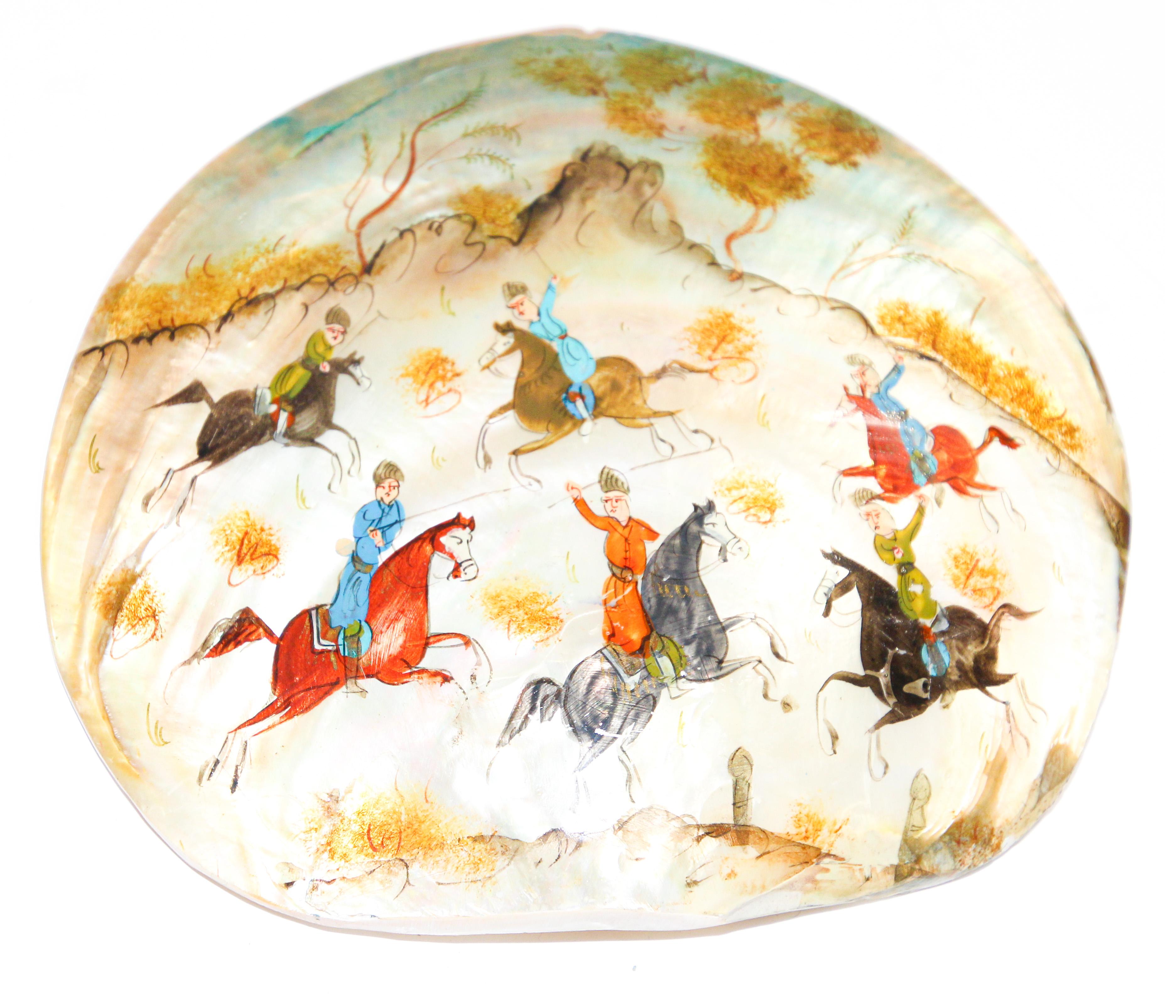 Hand Painted Asian Persian miniature painting on a sea oyster shell.
Middle Eastern Moorish design miniature painting on shell, very fine and colorful painting of men on horses playing polo.
Persian miniature painting on mother of pearl shell