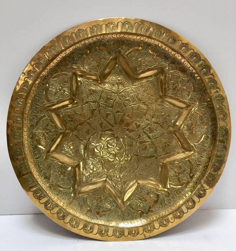 Middle Eastern Moorish antique round brass tray.
19th century handcrafted circular brass platter hammered with Islamic Moorish designs.
Heavy brass with fine floral and geometric designs.
Measures: Diameter 19.5