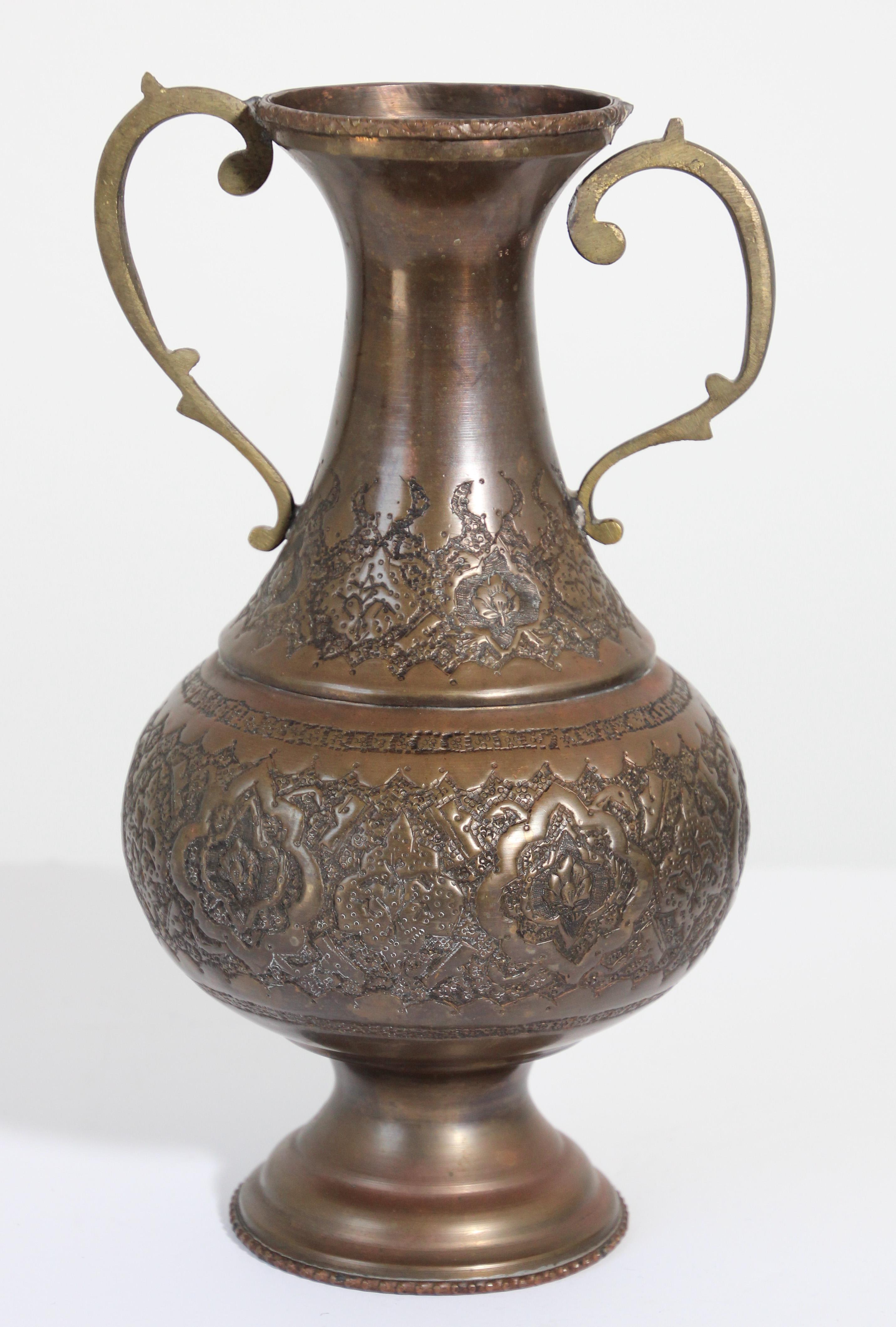 Middle Eastern Turkish copper vase, urn with traditional Islamic Moorish embossed design.
Handmade Islamic Moorish style engraved solid copper metal ware.
Footed vase with handle on each side.
One of the handle is detached, see pictures.
