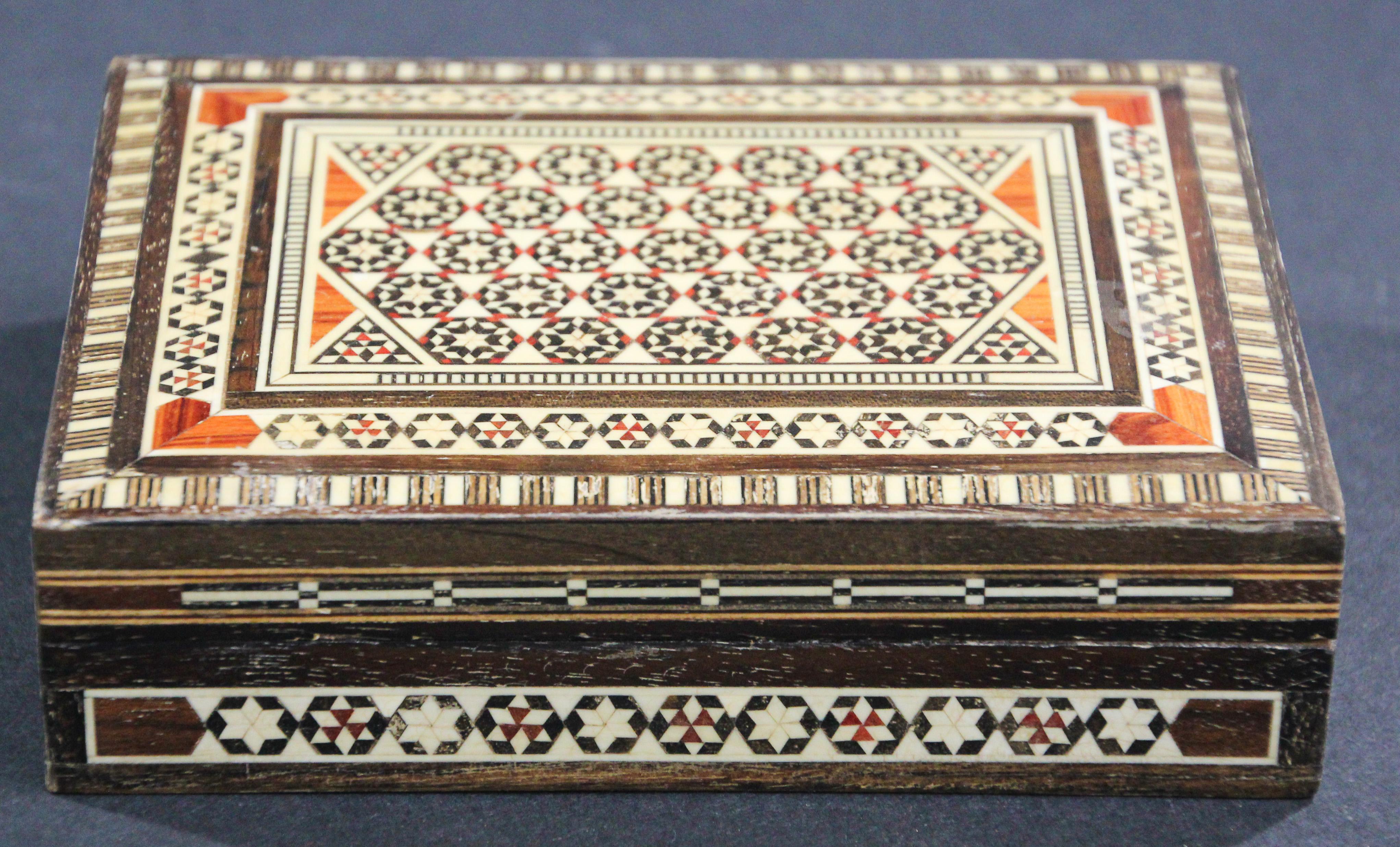 Exquisite handcrafted Middle Eastern mosaic marquetry inlaid walnut wood box.
vintage small trinket box intricately decorated with Moorish motif designs which have been painstakingly inlaid with mosaic marquetry, mother of pearl and