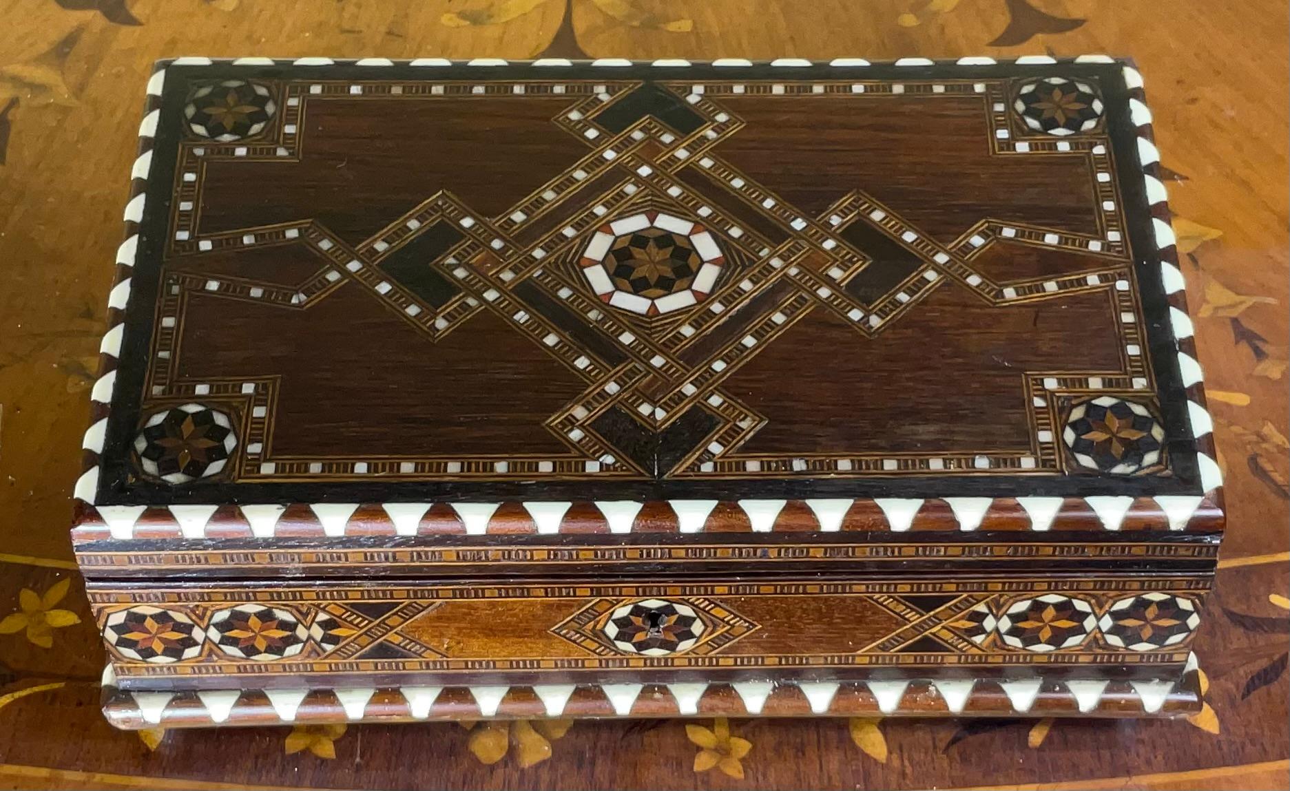 exquisite middle Eastern Moorish Syrian inlay jewelry box. This box is intricately inlaid with Moorish motif designs which have been uniquely inlaid with bone, and fruitwood, four brass feet.
 Key is not included.
Jewelry box’s interior is lined