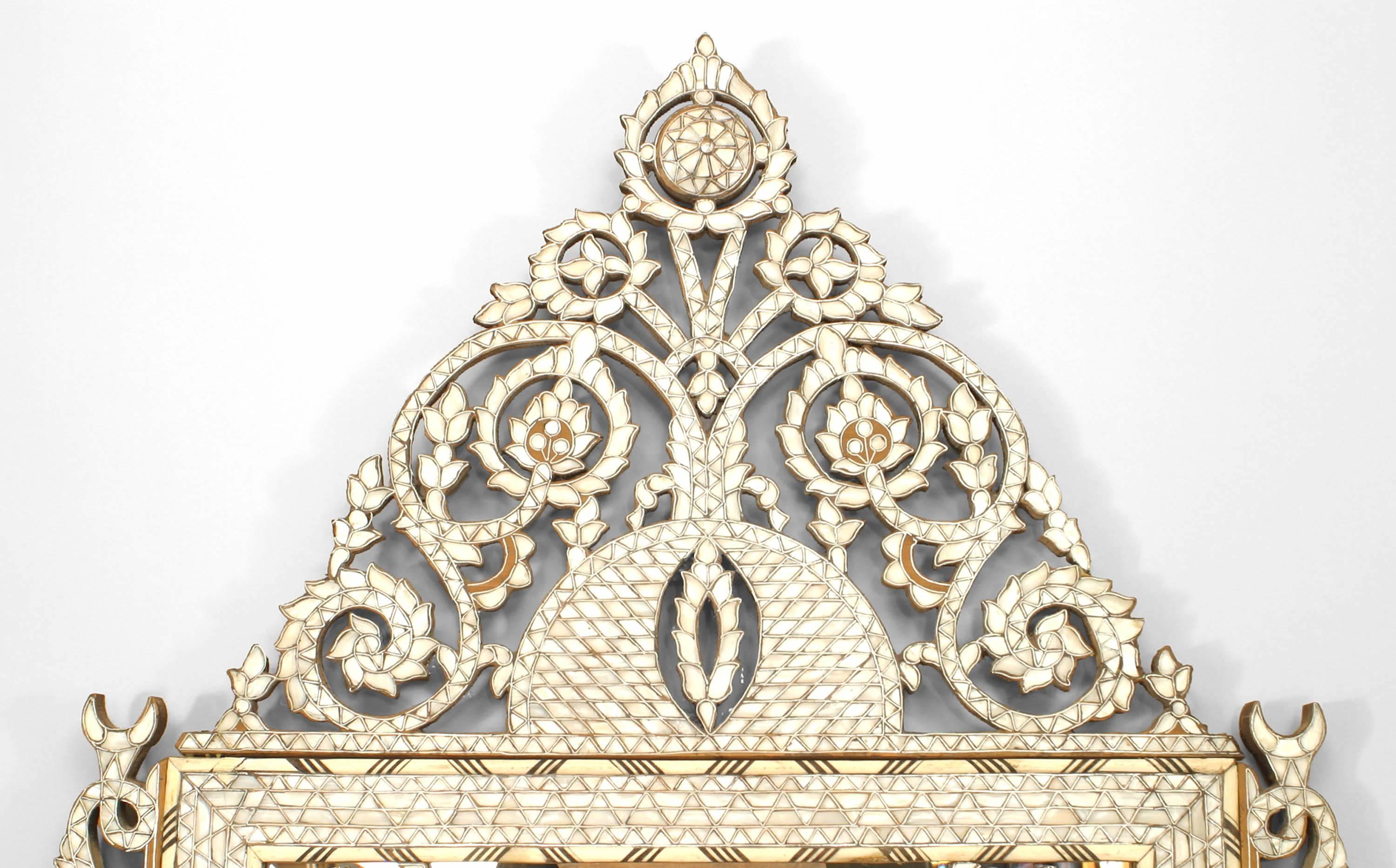 Middle Eastern Syrian (Moorish style) (20th century) wall mirror with inlaid mother-of-pearl, ebony and bone with a shaped filigree floral pediment.
   