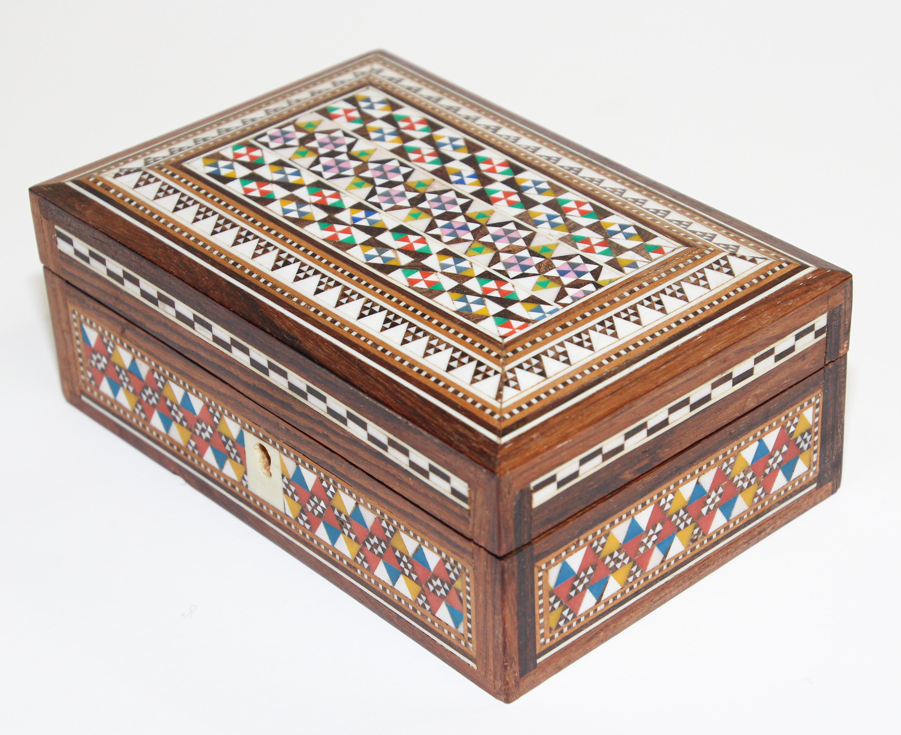 Exquisite handcrafted Middle Eastern Lebanese, Egyptian mosaic marquetry wood box inlaid.
Small vintage walnut Syrian style box intricately decorated with Moorish motif designs which have been painstakingly inlaid with mosaic shell and