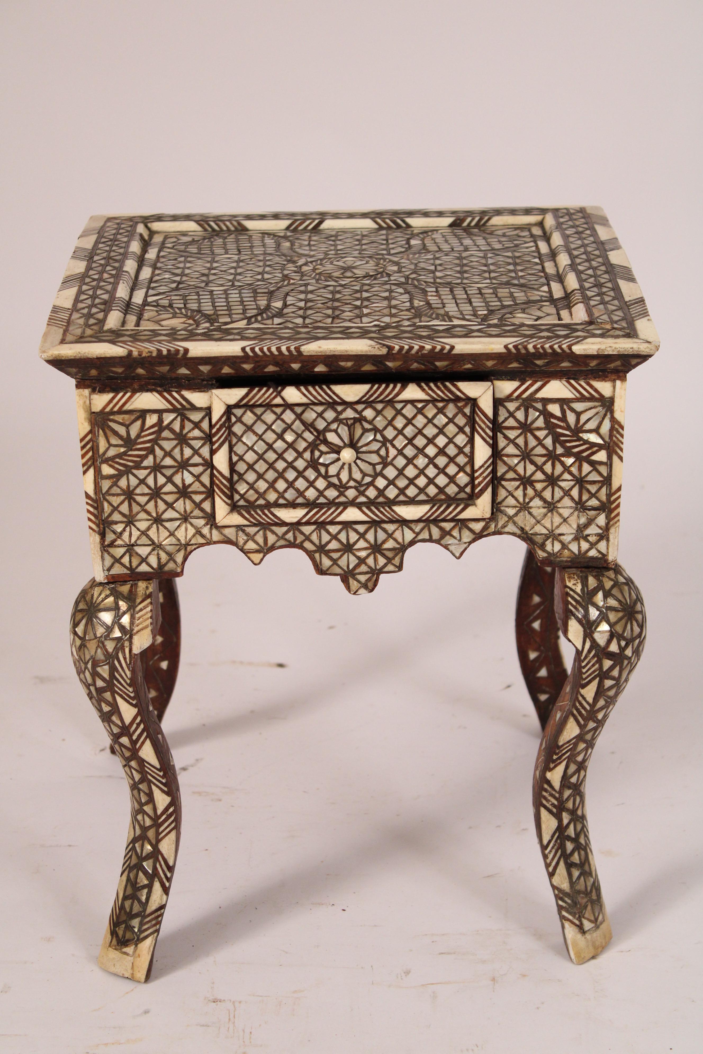 Middle Eastern mother of pearl and bone inlaid side table, circa 1920's. With a square mother of pearl and bone inlaid slightly overhanging top, a frieze drawer, scalloped apron, resting on cabriole legs. 