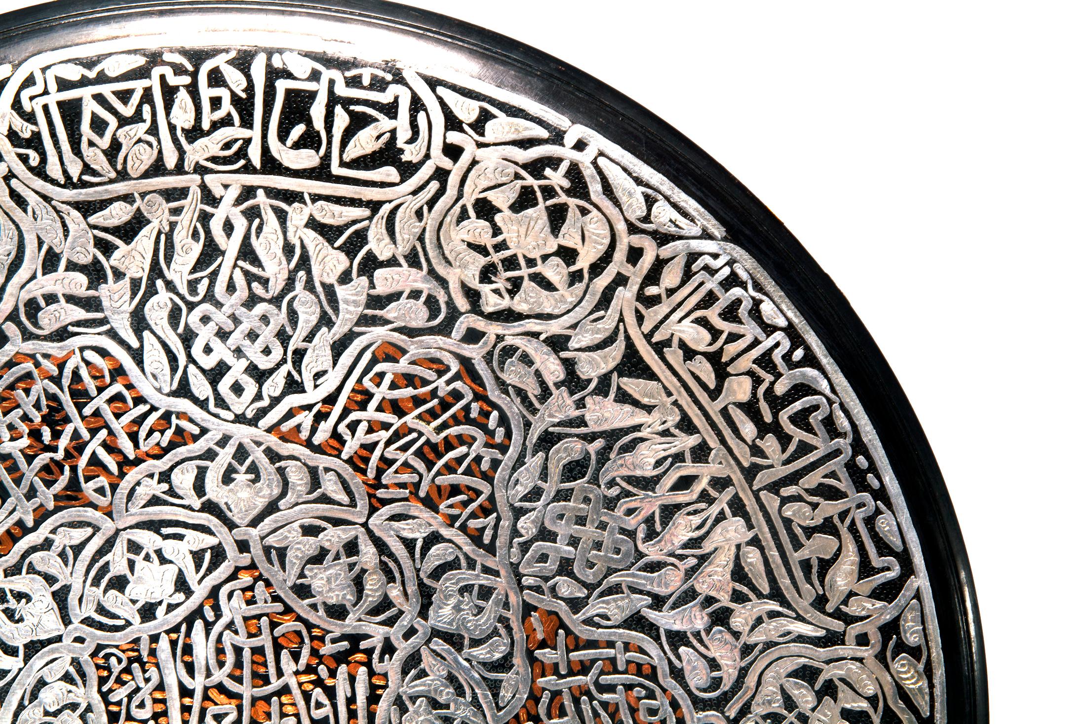 Round copper tray with Arabic calligraphy. Tray inlaid with silver.
Could be used as a decorative wall hanging or as serving tray. Soldered hook is on the back.
 