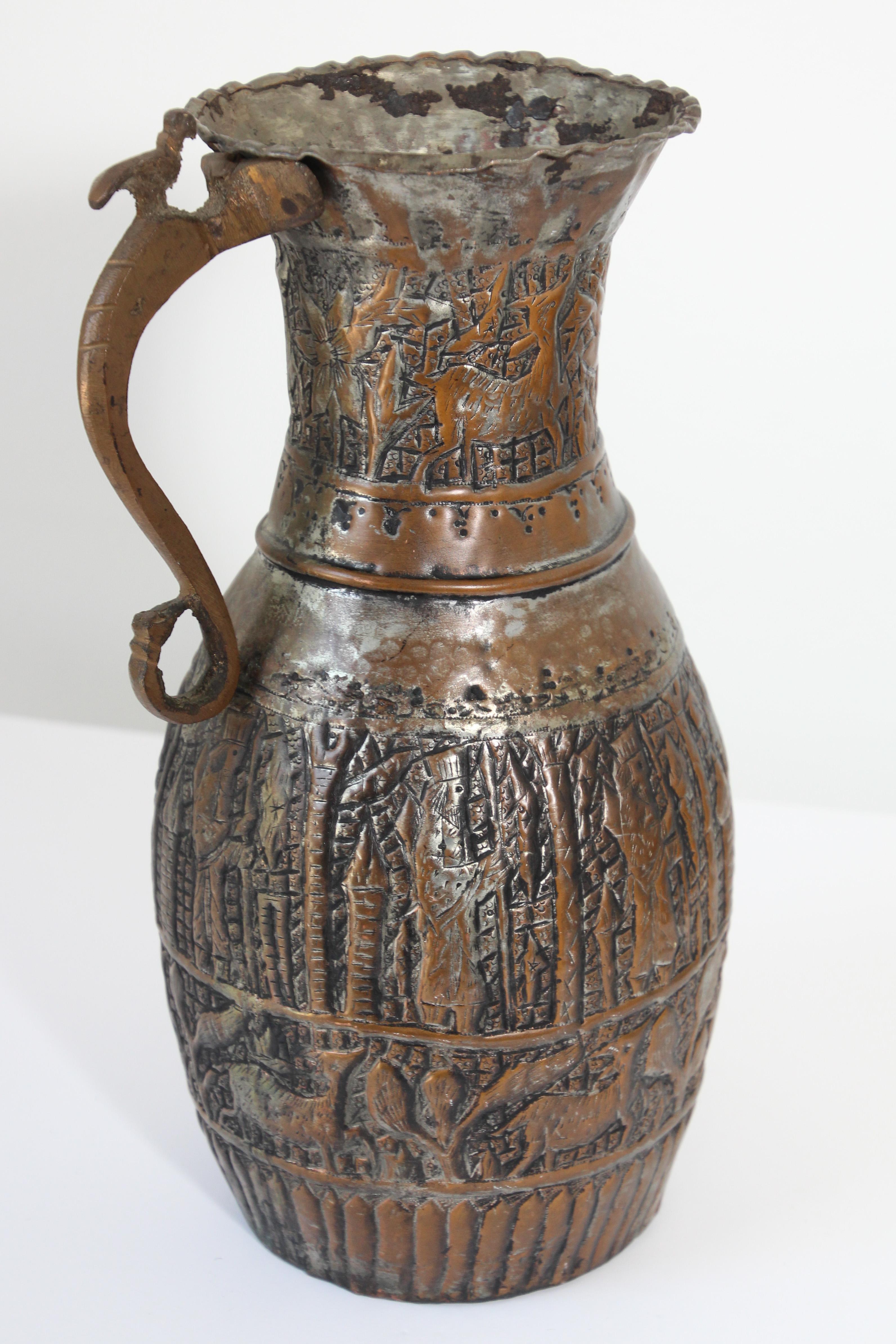 19th century Middle Eastern Arabian tinned copper coffee pot.
A bird on top of the handle.
Hand-hammered and chased copper with figures and animal designs riveted finish on handle.
Missing lid, probably used to make coffee.
Middle Eastern