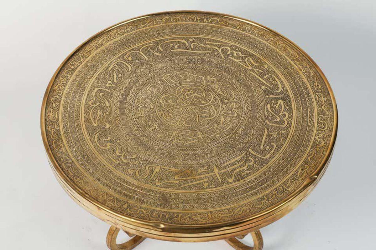 Middle Eastern Moorish Vintage brass repousse tray table with gilt iron stand.
The embossed Art Deco style brass top is decorated with Arabic calligraphy writing and repousse geometric Islamic Moorish designs.
The Arabic words are poetry from the
