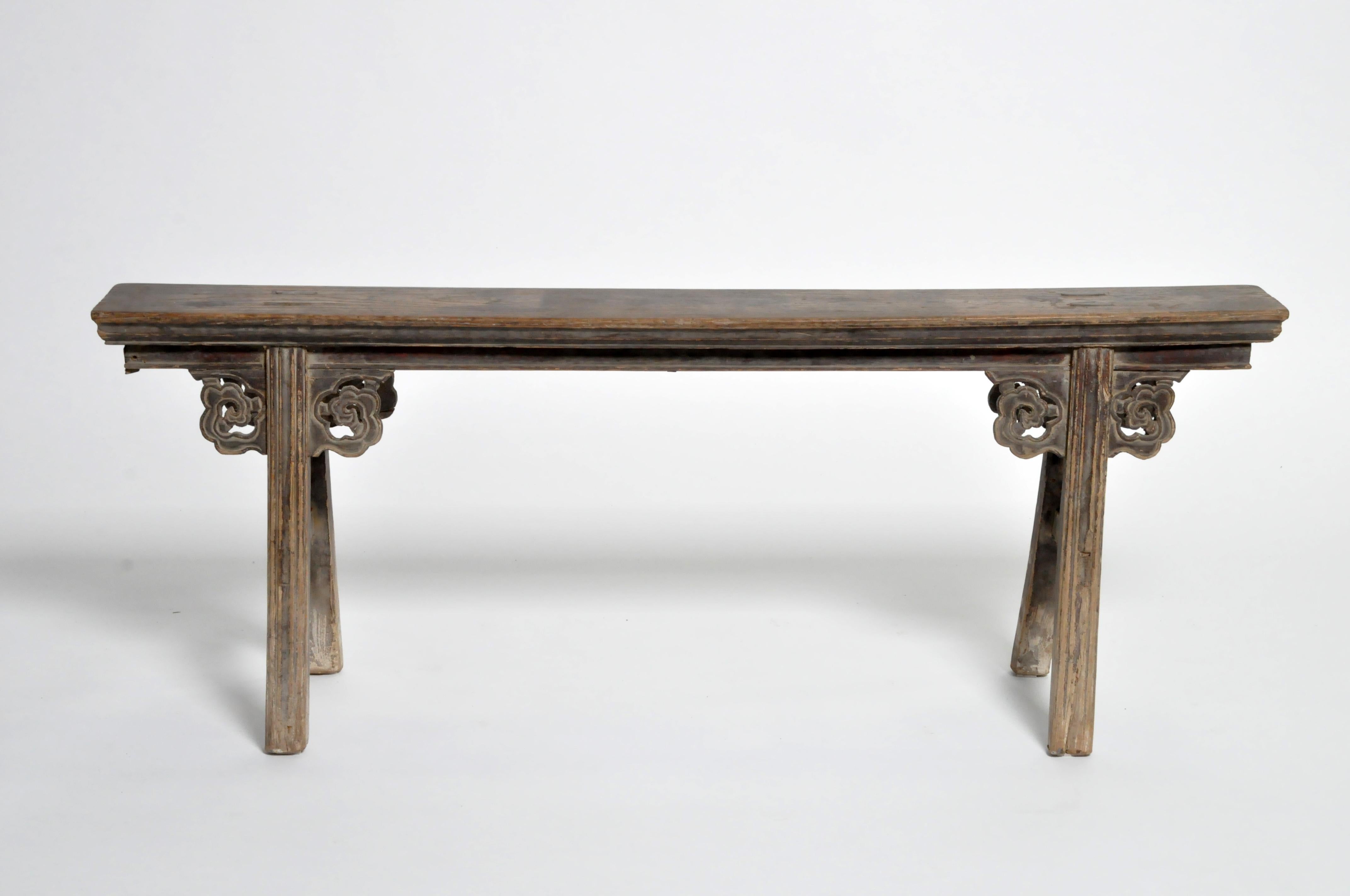 This classic two-person Chinese bench features stretchers, mortise and tenon joinery, and traces of original lacquer. It has a beautiful aged, all-original patina.