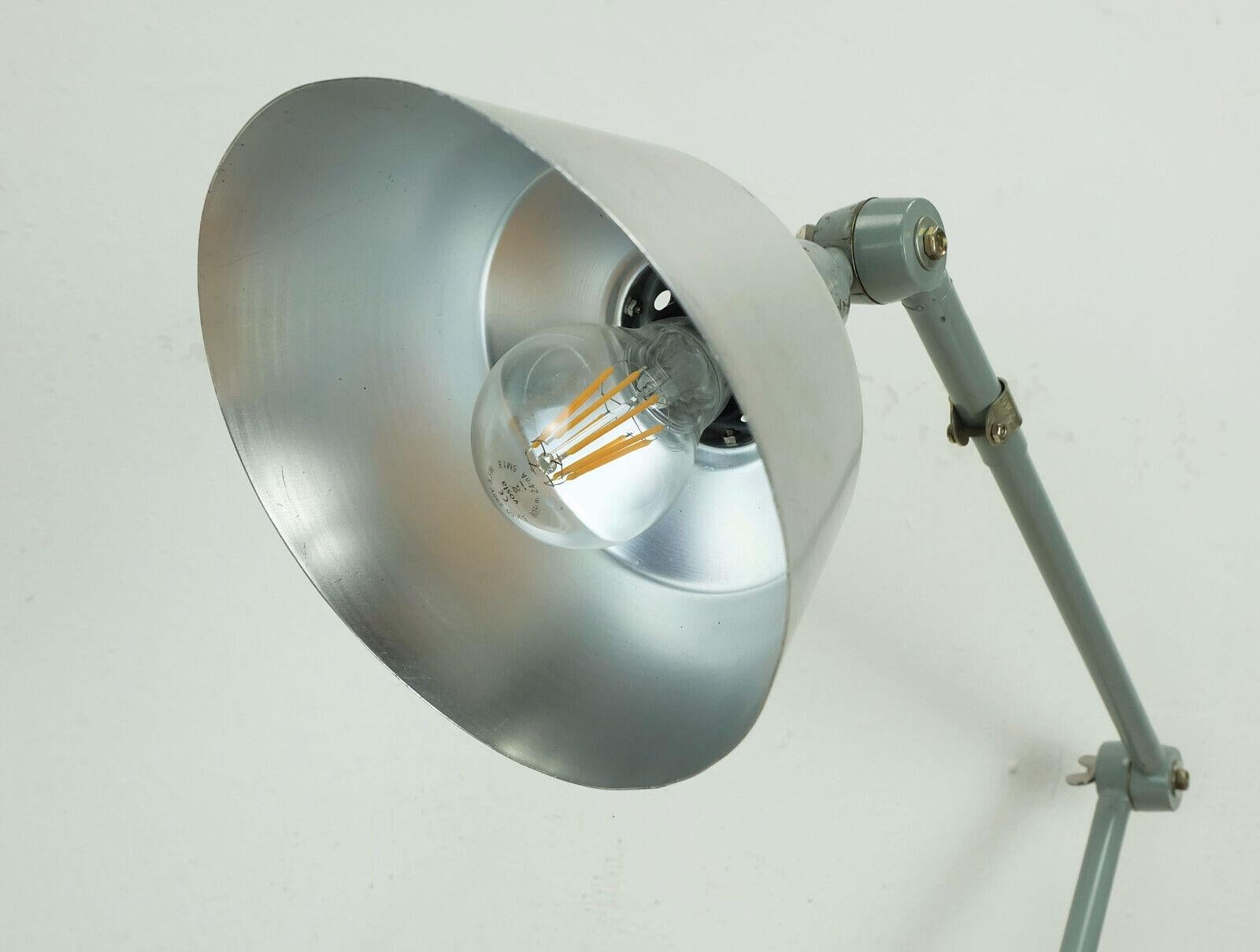 Midgard R2 desk lamp, originally designed by Curt Fischer, this version was manufactured in the 1960s. Adjustable height thanks to several joints and rotatable on the base. The shade is made of aluminum, the arm is made of gray painted metal. The