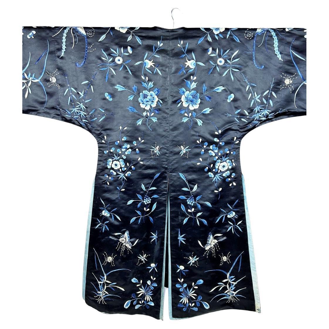 Circa 1880-1900
China 

Kimono coat in densely embroidered midnight-blue silk satin in stem stitch and bow stitch dating from the late Qing period. Kimono cut with wide sleeves, slit sides and round collar. Closes at the front with five chased brass
