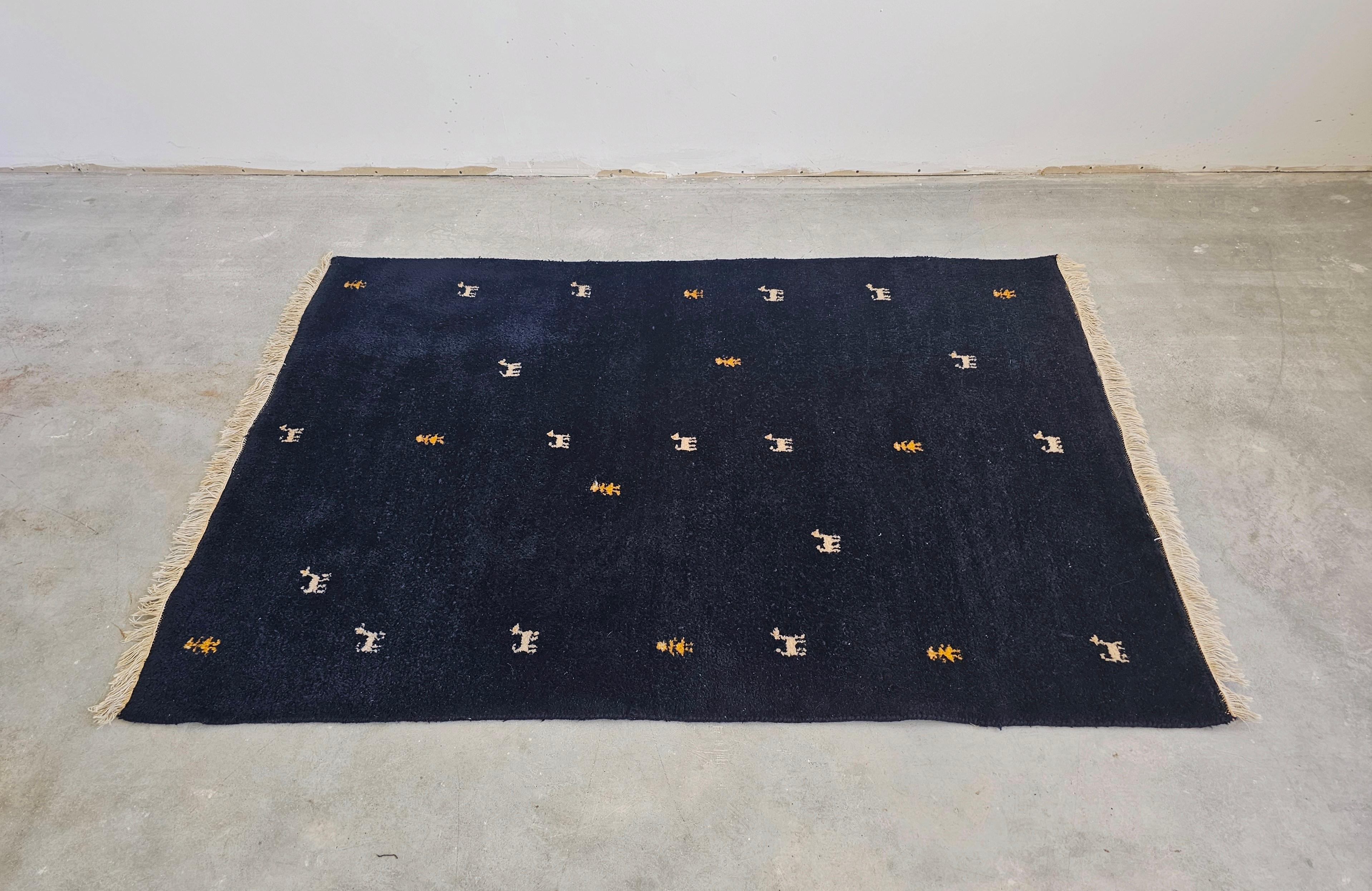 In diesem Angebot finden Sie eine einzigartige Gabbeh Teppich in Midnight blau, fast schwarz Wolle, mit sehr begrenzten Anzahl von charakteristischen abstrakten Mustern, die Tiere und Menschen ähneln. Sein Design vereint zwei Ästhetiken, die nicht