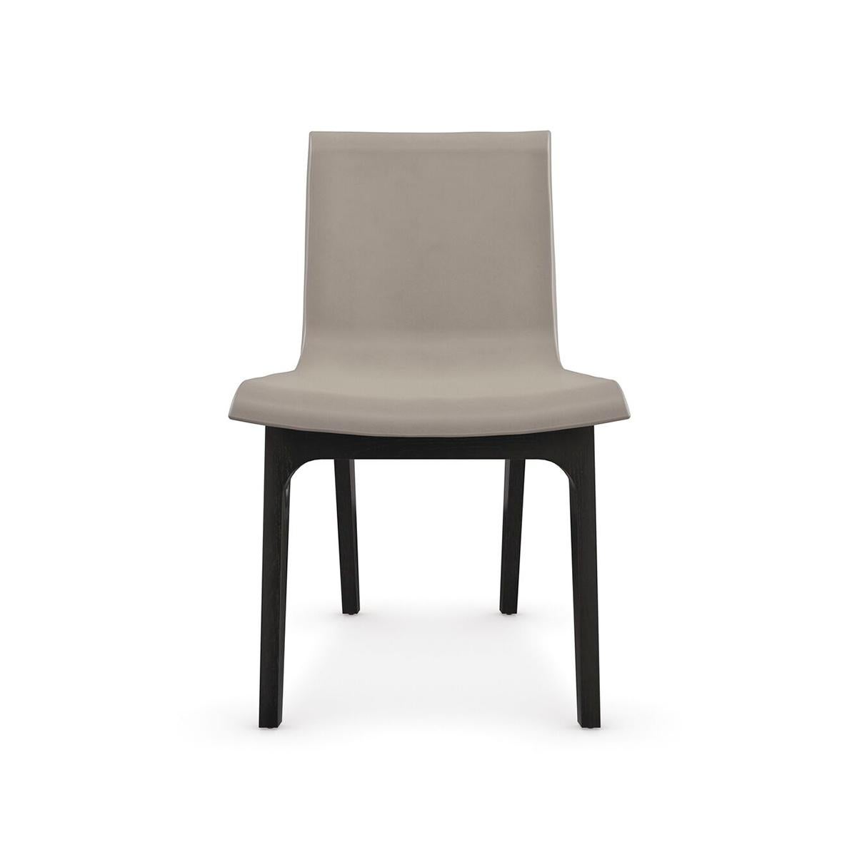 A masterful blend of luxury and comfort, the dining chair introduces a simple yet elegant mix of textures and materials. Comfortably curved, the seamless back and seat are dressed in taupe leather, contrasted by wood legs in a dark Basalt finish. A