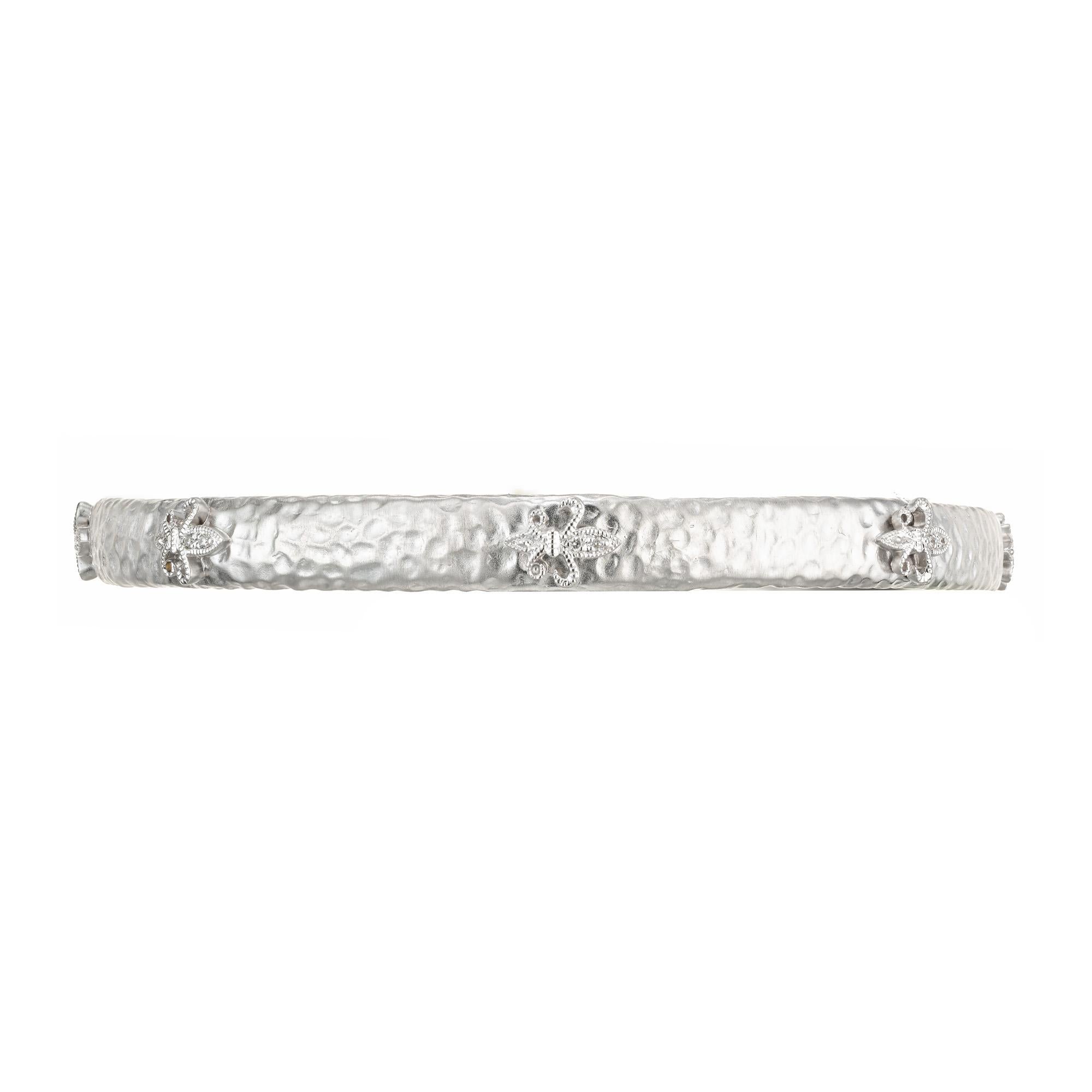 Diamond bangle bracelet. 14k white gold textured slip on bangle bracelet with 16 round brilliant cut diamonds set in Fleur De Lis sections. Fits a 7.5 Inch wrist.
Follow us on our 1stdibs storefront to view our weekly new additions and 5 Star