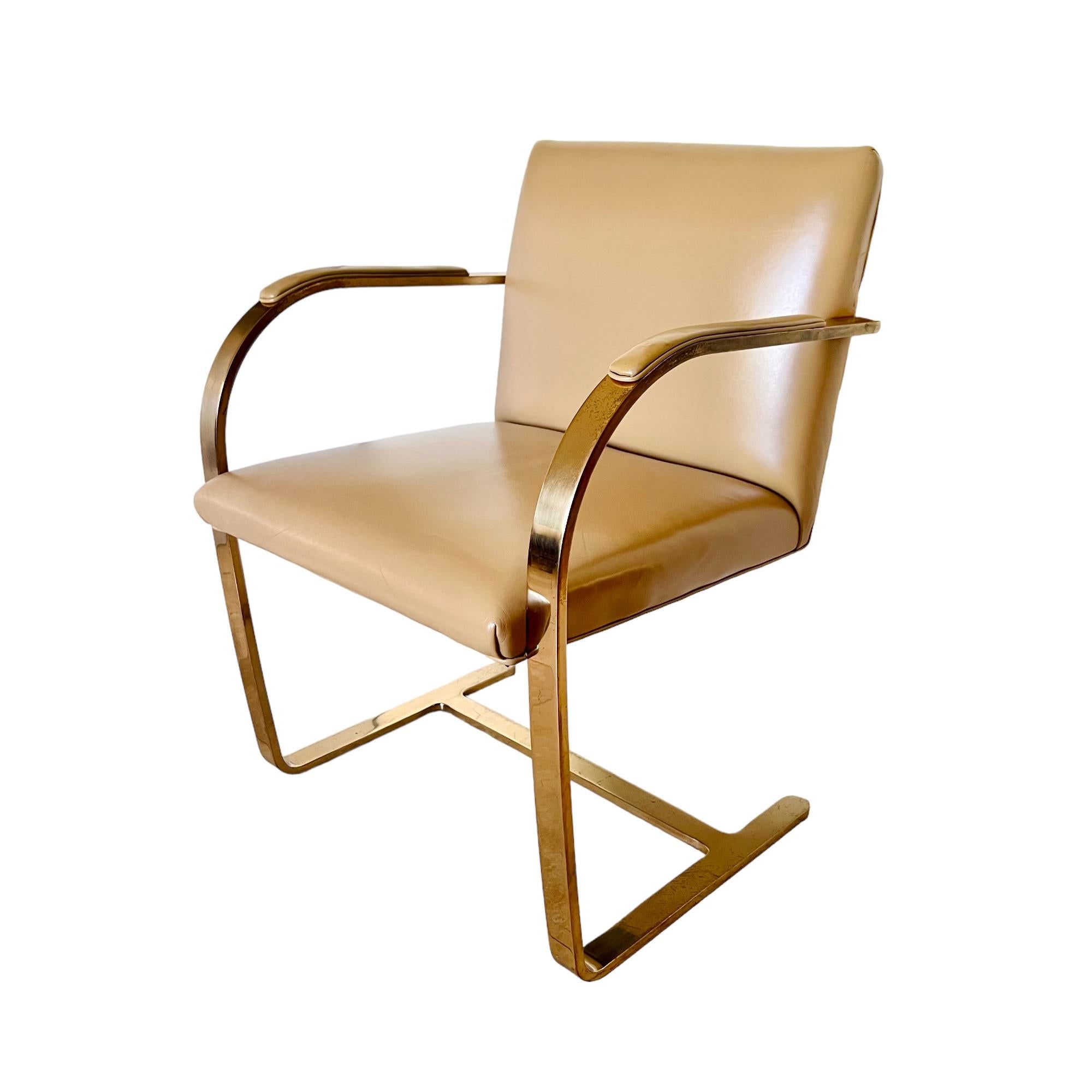 A vintage mid-century modern Brno flat bar armchair designed by Ludwig Mies van der Rohe and produced by Interior Crafts. Special commission solid brass frame with tan leather chair back, seat and armrest pads.

Dimensions: 23