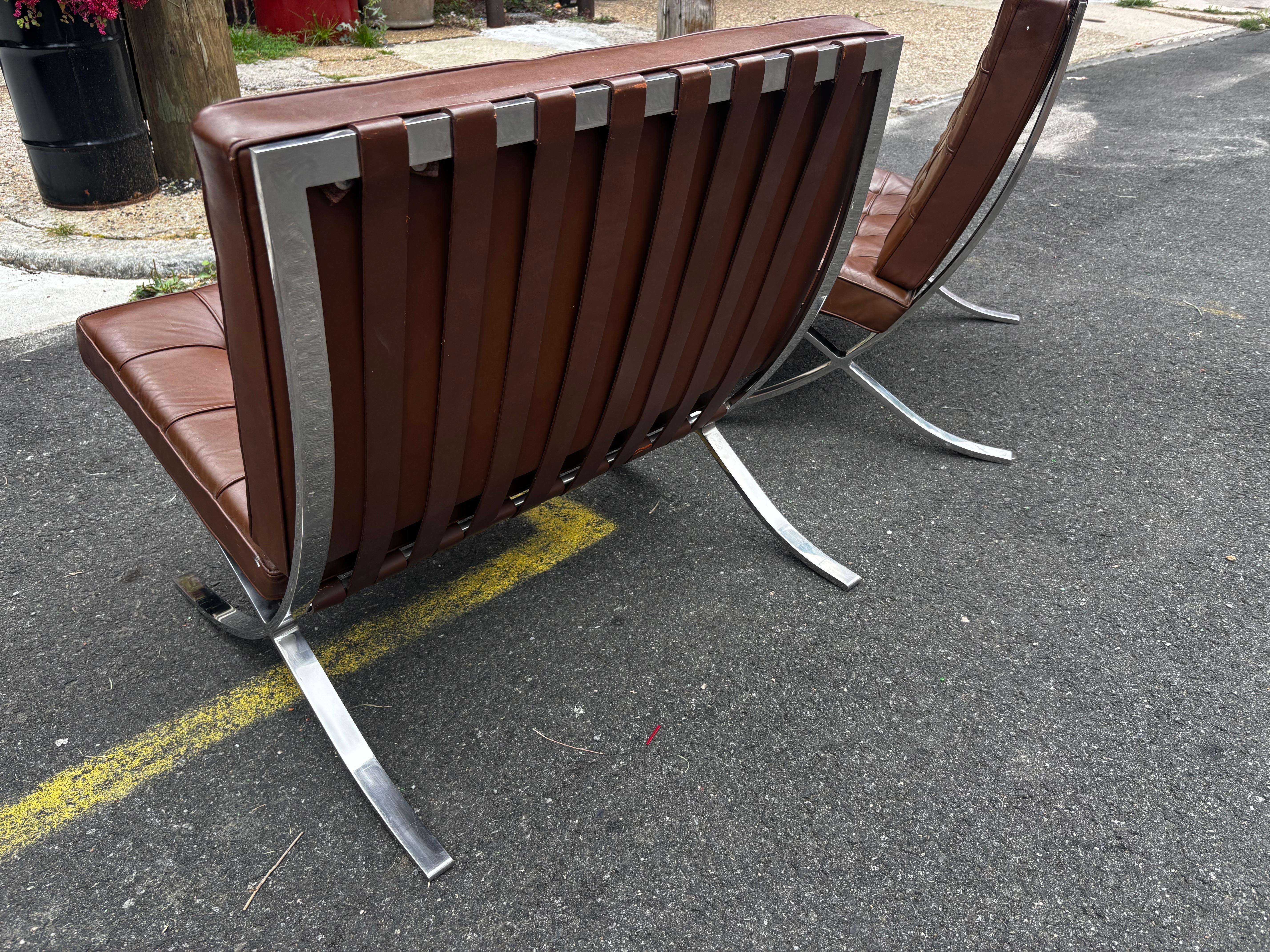 Paire de chaises Mies Van der Rohe en cuir brun chocolat avec armatures en acier inoxydable.  Nouvelles sangles au bas de la zone de siège sangles de siège sont une légère différence dans les coussins bruns !  Voir la photo !  Les chaises datent de