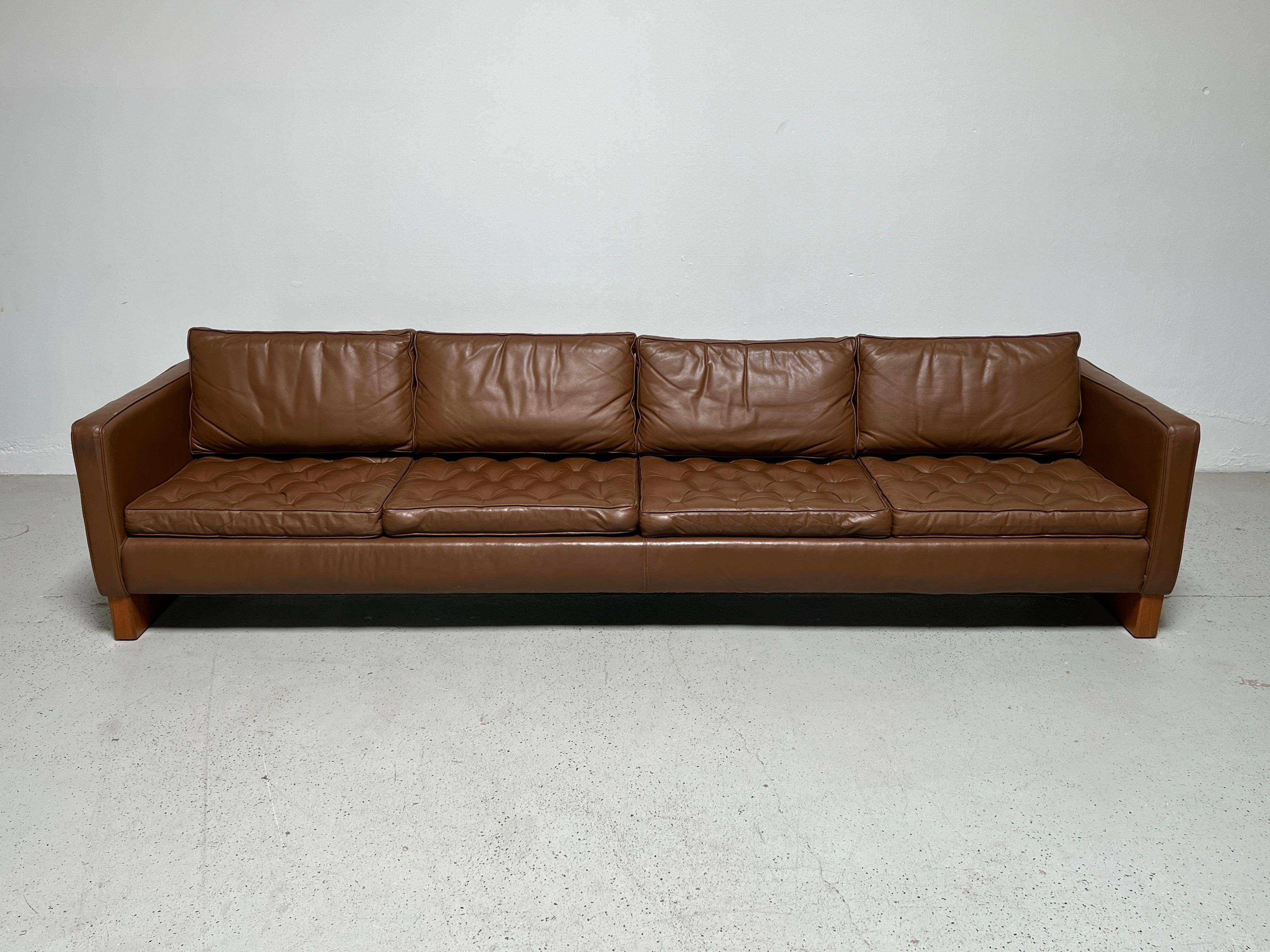 A large four seater sofa designed by Mies van den Rohe for Knoll. A rare design made in limited production. This version with oak runners and newer leather upholstery.