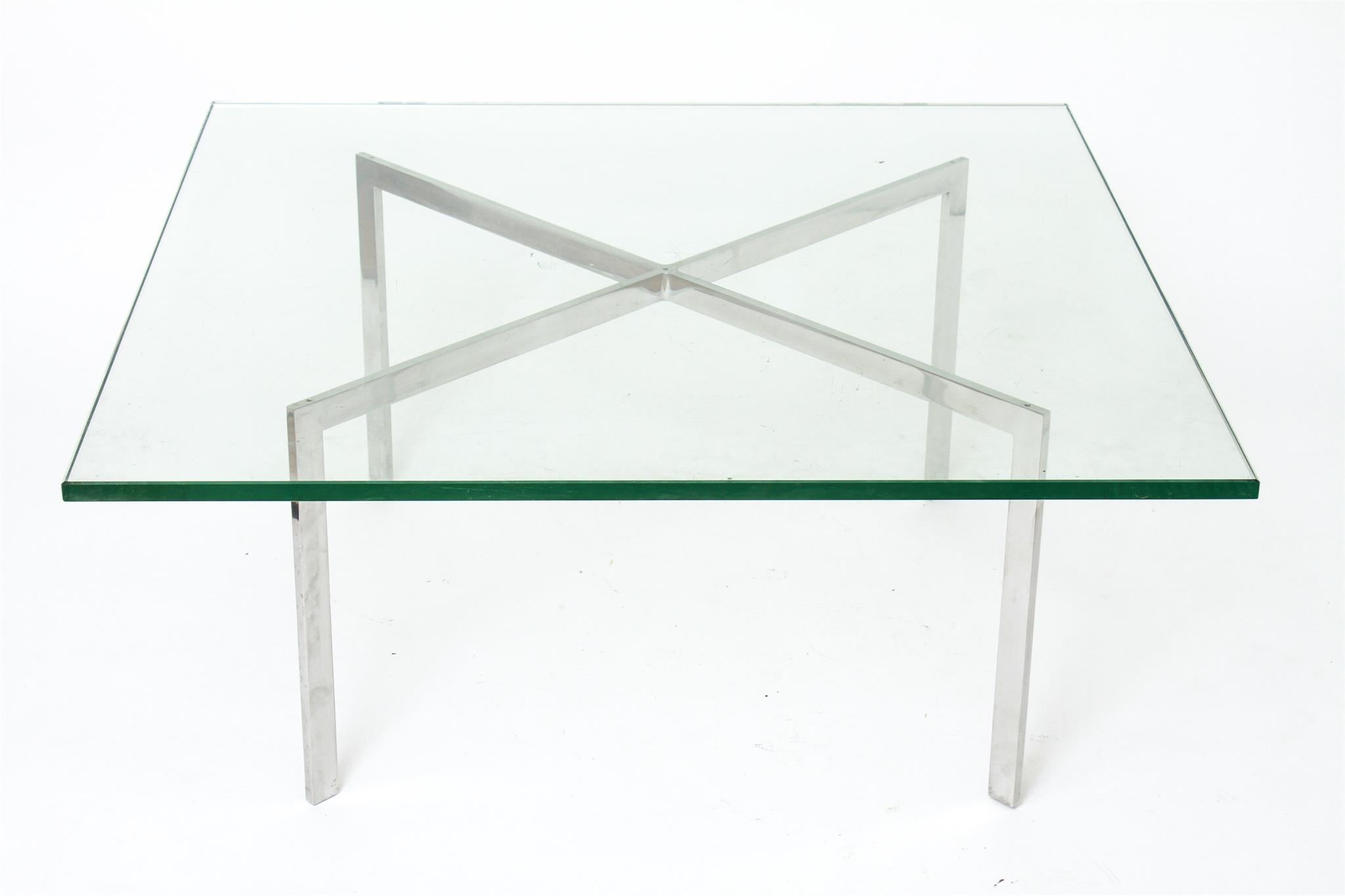 Modernist Barcelona coffee or cocktail table designed originally by Ludwig Mies van der Rohe in 1929 and re-edited by Knoll in the mid-20th century. The table features an X-shaped base with a polished chrome finish and a thick square glass top.