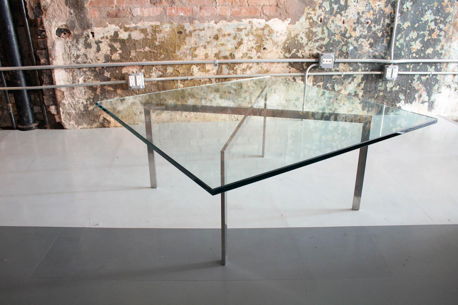 This is a Mies van de Rohe for Knoll Barcelona table. The glass is quite thick and the piece features a solid steel base.